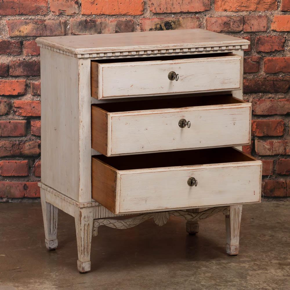 This petite Swedish Gustavian chest of drawers is a perfect blend of style and functionality. The natural pine comes through where the white painted finish has been lightly worn away giving this chest of drawers an elegant country feel. This would
