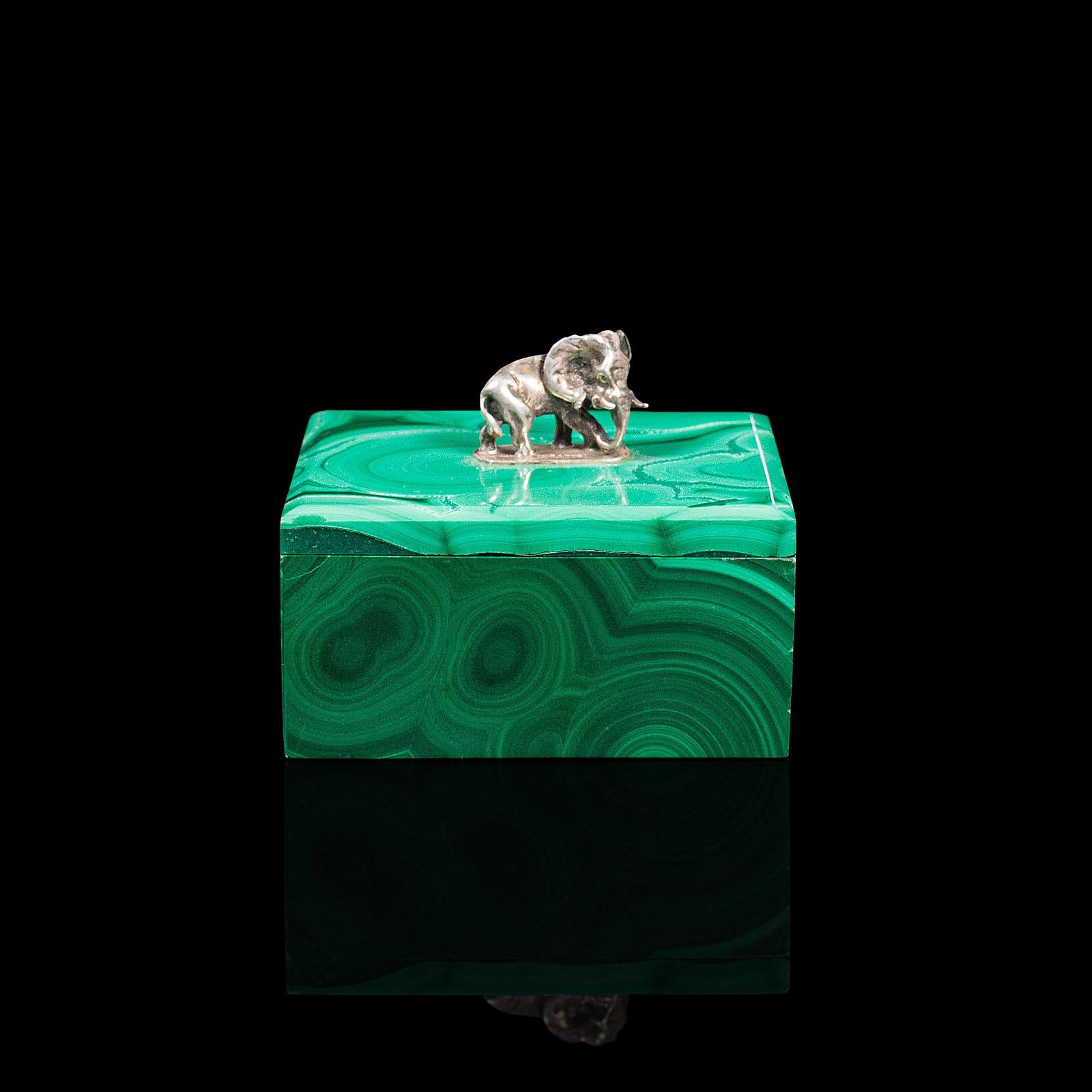 This is a small antique trinket box. An English, malachite and silver decorative box with elephant finial, dating to the early Victorian period, circa 1850.

Wonderfully diminutive, with captivating natural stone
Displaying a desirable aged