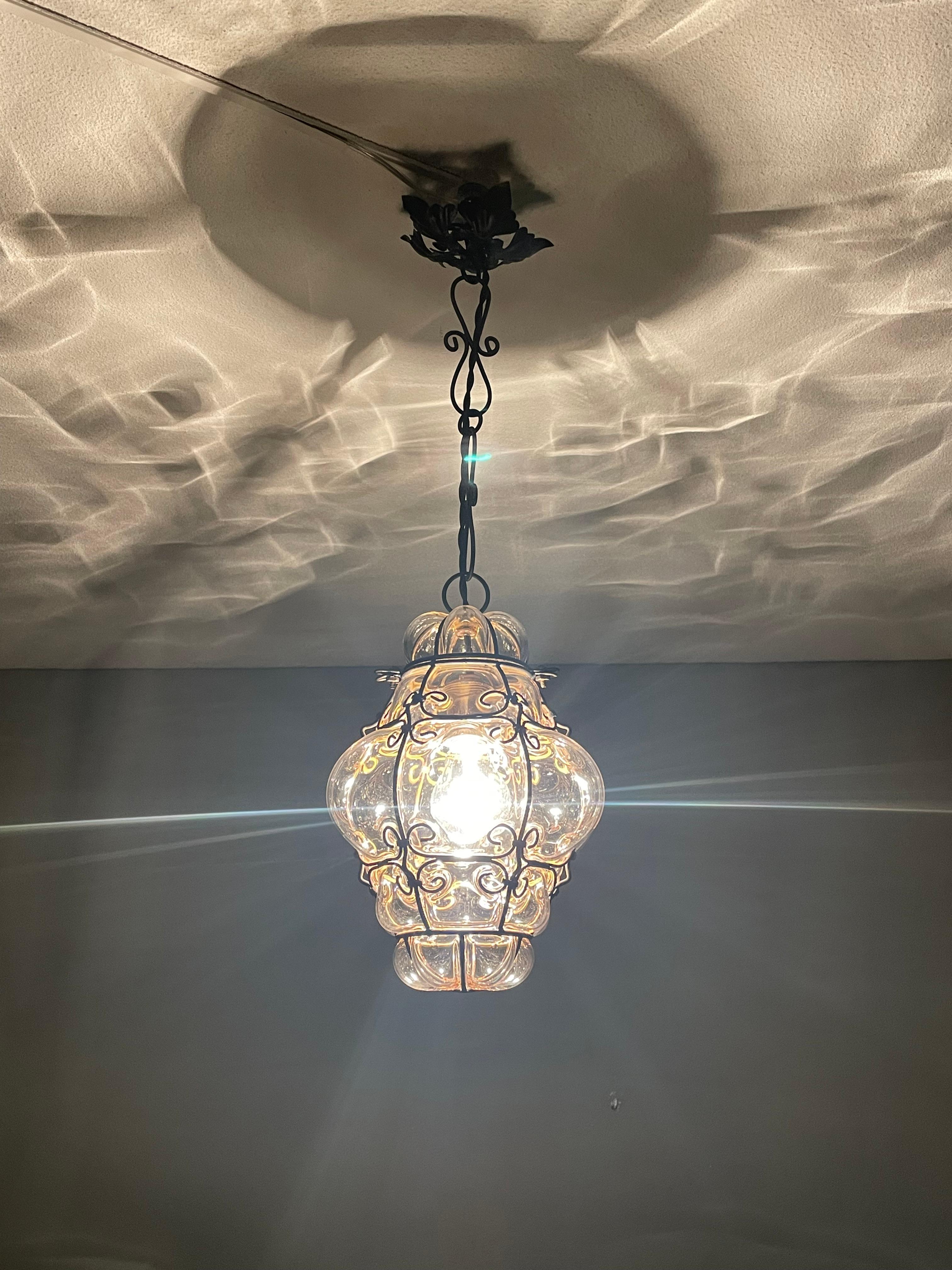 Small and stunning Venetian pendant in a forged iron frame.

This adorable and antique Venetian pendant light is one of the smallest of its kind that we ever had the pleasure of offering. However, when it comes to condition, style and true