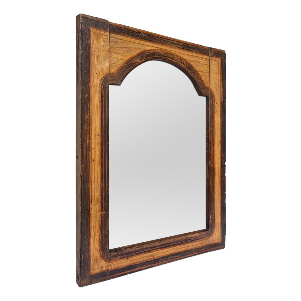 Small antique wooden mirror in the Folk Art style, circa 1890, of rectangular shape with a cut-out frame in the form of a barrel vault, decorated with painted brown polychromed fillets patinated by time. Maintained and treated wood. (Frame width: