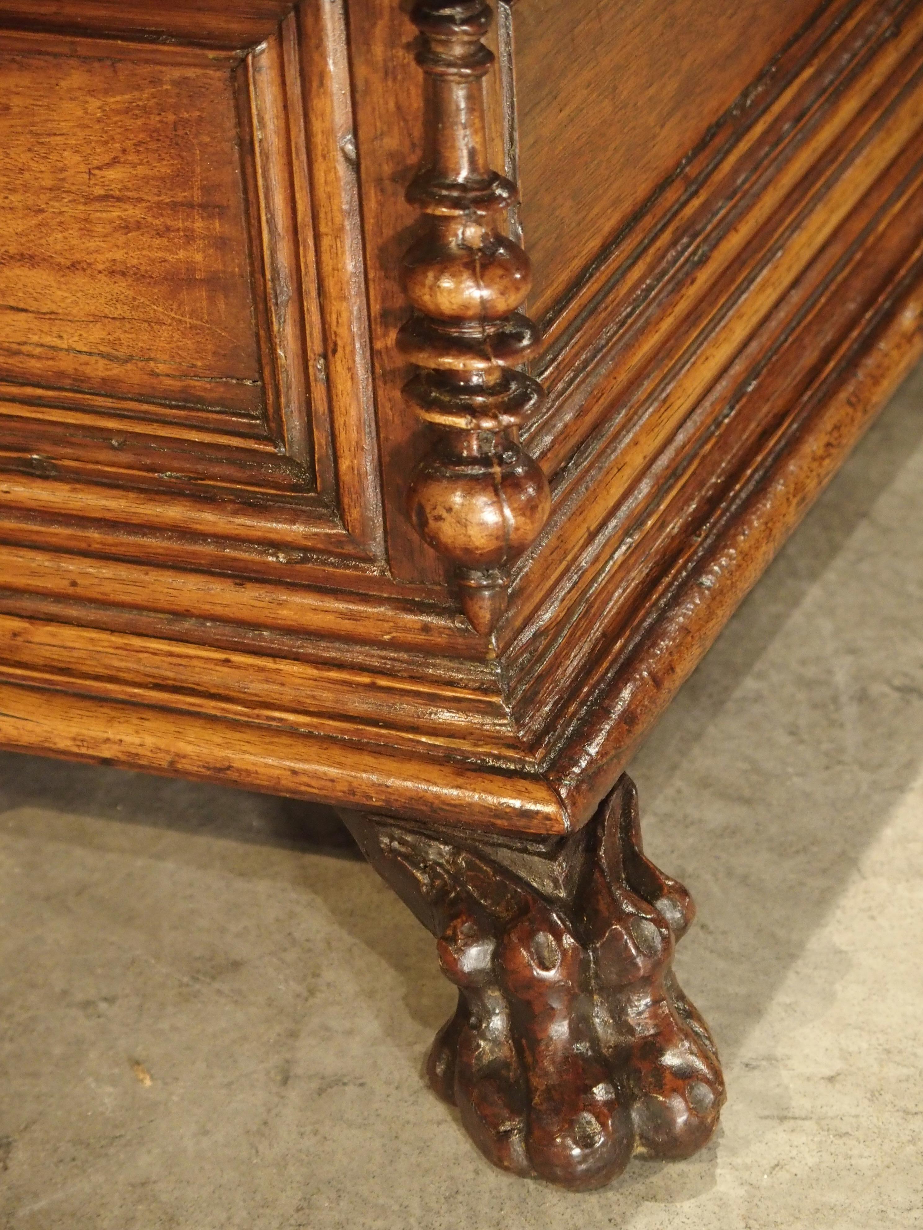 This small tabletop trunk has been made with walnut wood and comes from Northern Italy. Its stepped out panelled front add depth to an otherwise simple and clean frontage. There are two turned motifs at either side which are slightly different from