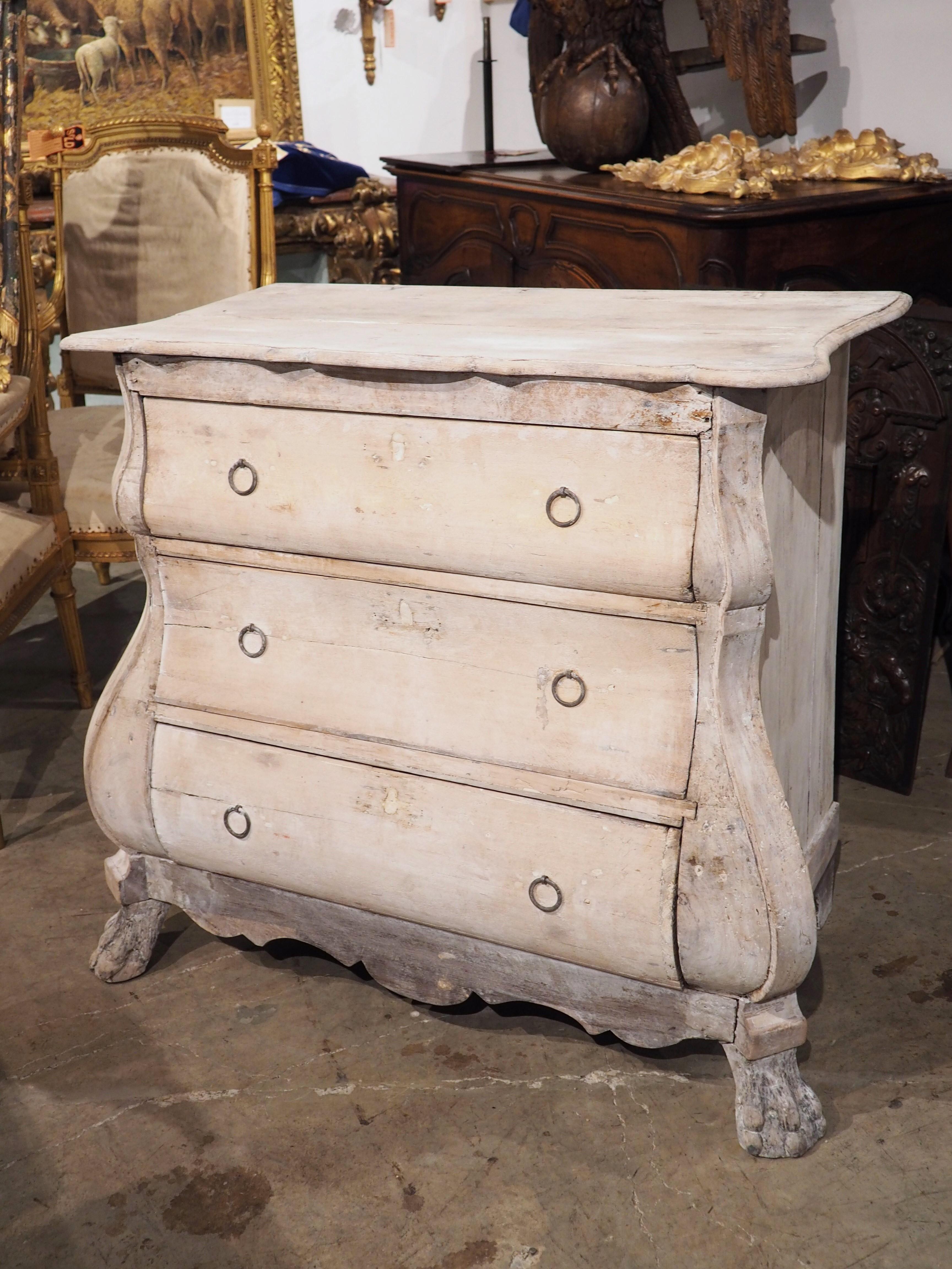 A very unique small chest of drawers, hand-carved in the Netherlands, circa 1780, the wood has been whitewashed at some point over the last 250 years, resulting in an ashen white color with hints of cream and beige. The shapely commode has a bombe