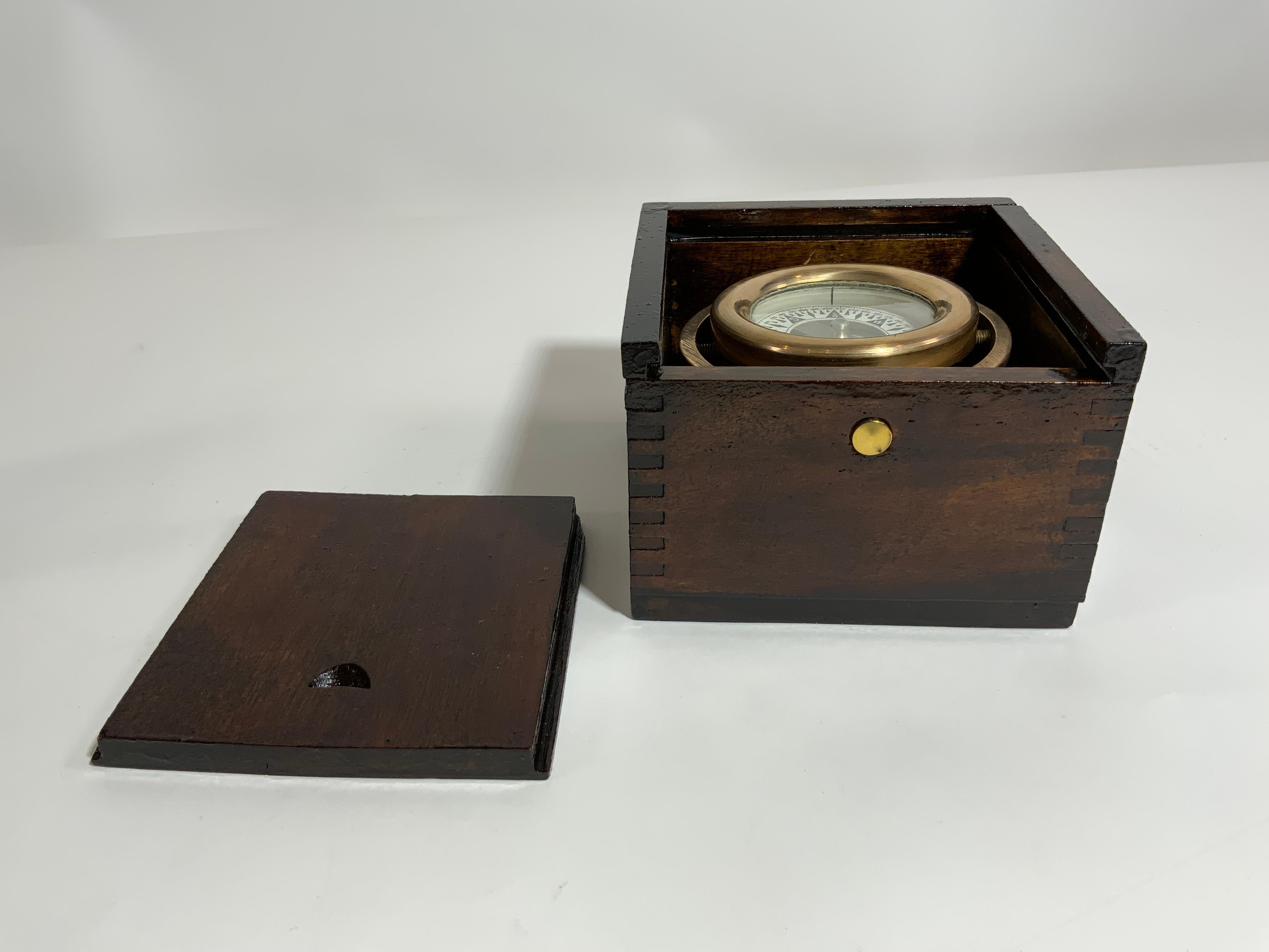 Polished brass boat compass by Wilcox Crittenden of Middletown, Connecticut. Fitted to a varnished, dovetailed box. Sliding lid. Great little relic. Circa 1940.

 Overall Dimensions: 5