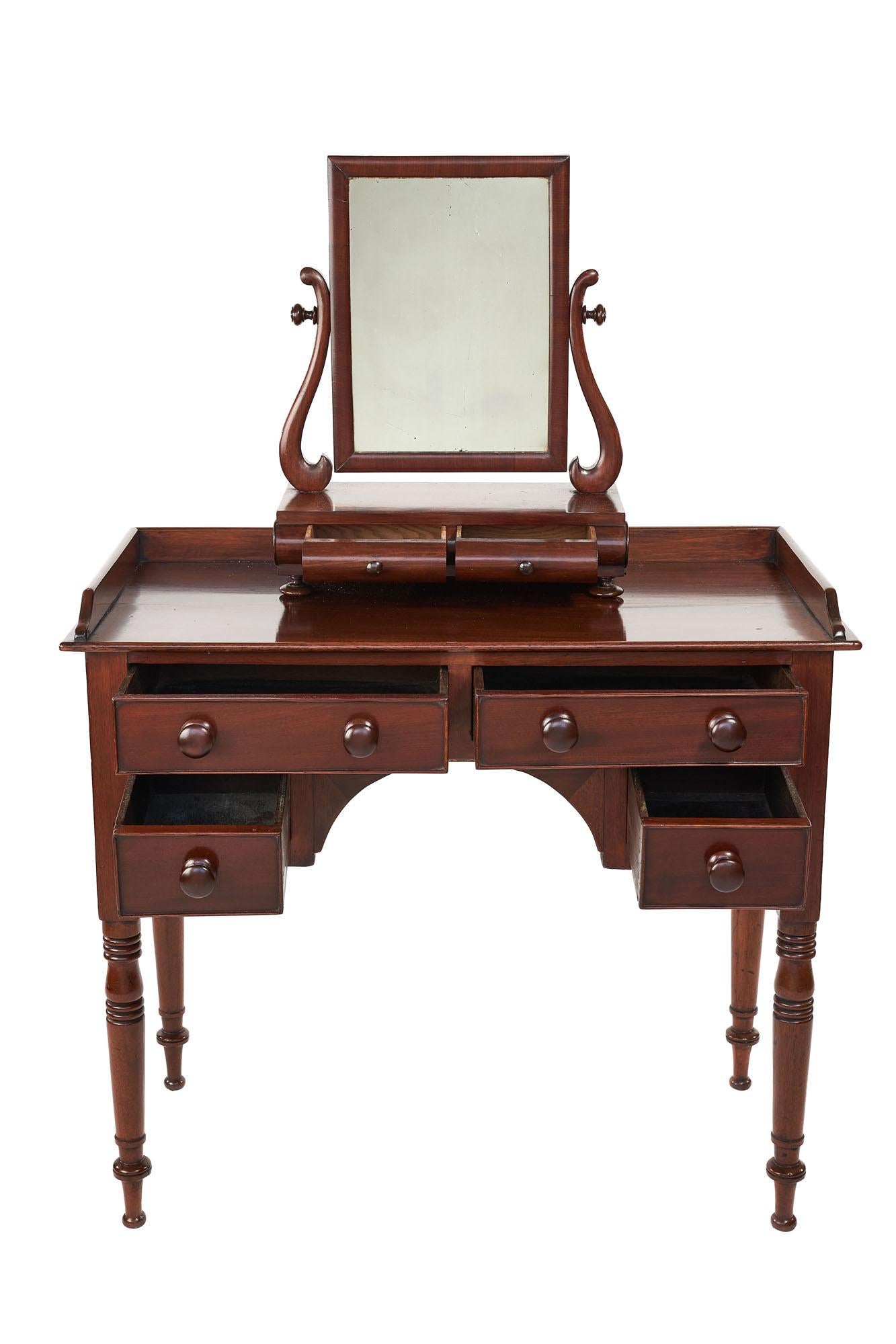 Small antique William IV mahogany vanity/dressing table with swing mirror having a quality mahogany top with mahogany three quarter gallery, mahogany mirror with S shaped supports, two drawers to the base with original mahogany knobs and bun feet,