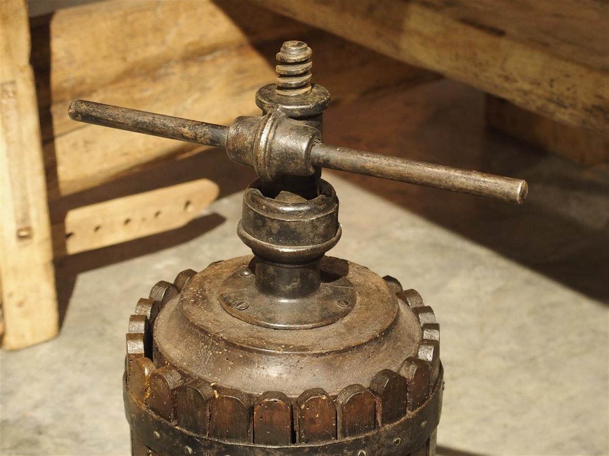 This charming, small antique French grape press dates to the mid to late 1800s. It is made from cast iron and wood, and it was used for testing small batches of grapes, more specifically, the readiness of the grape. The turning mechanism at the top