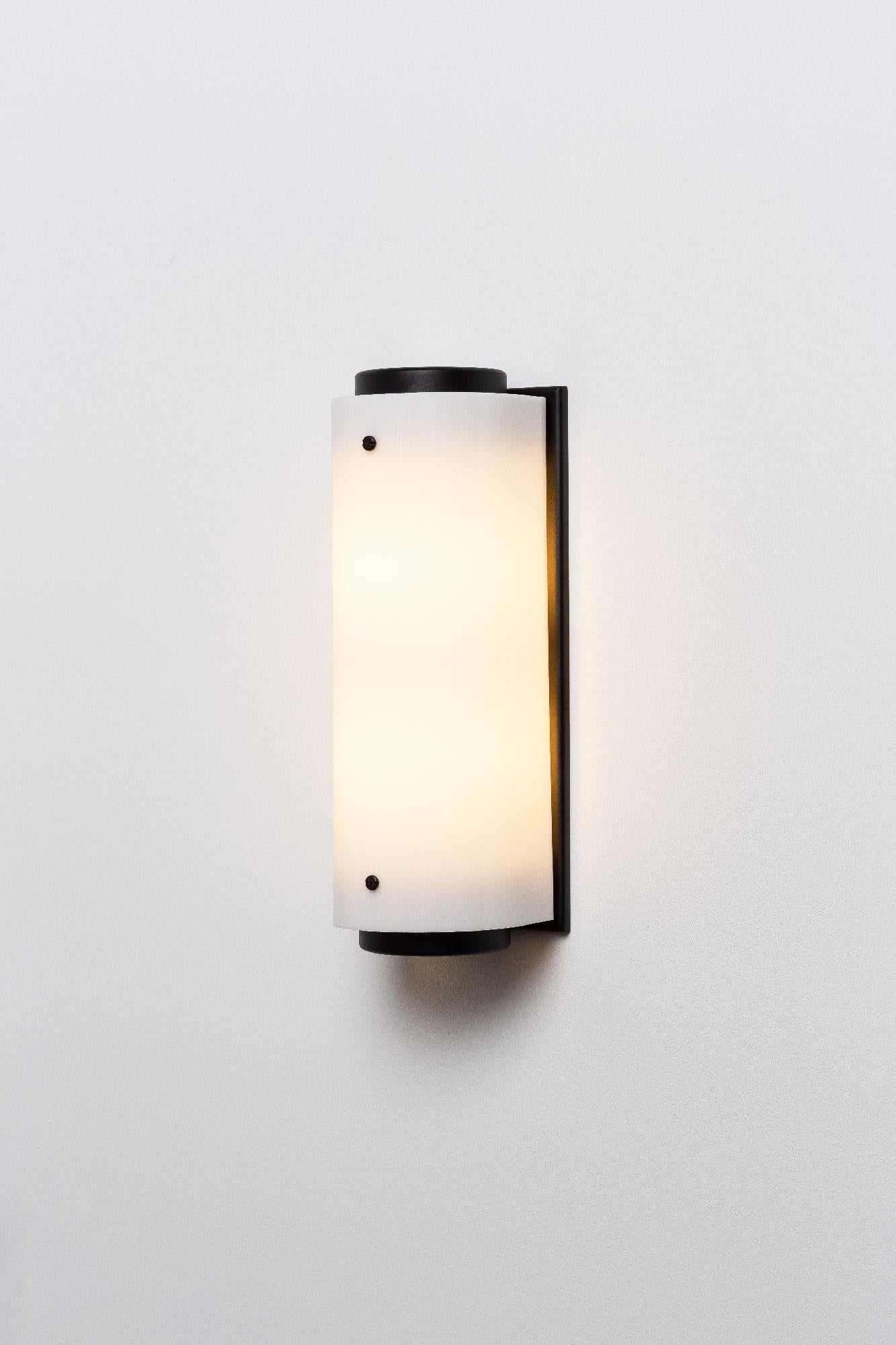 The arc sconce is made of a solid black body and backplate with a white Lucite shade and black screws.

Small: W 5.25in (13.5cm) x D 5.25in (13.5cm) x H 12in (30.5cm)

(2) 60W medium base socket
Raw brass and white Lucite
Handmade in LA
UL listed /