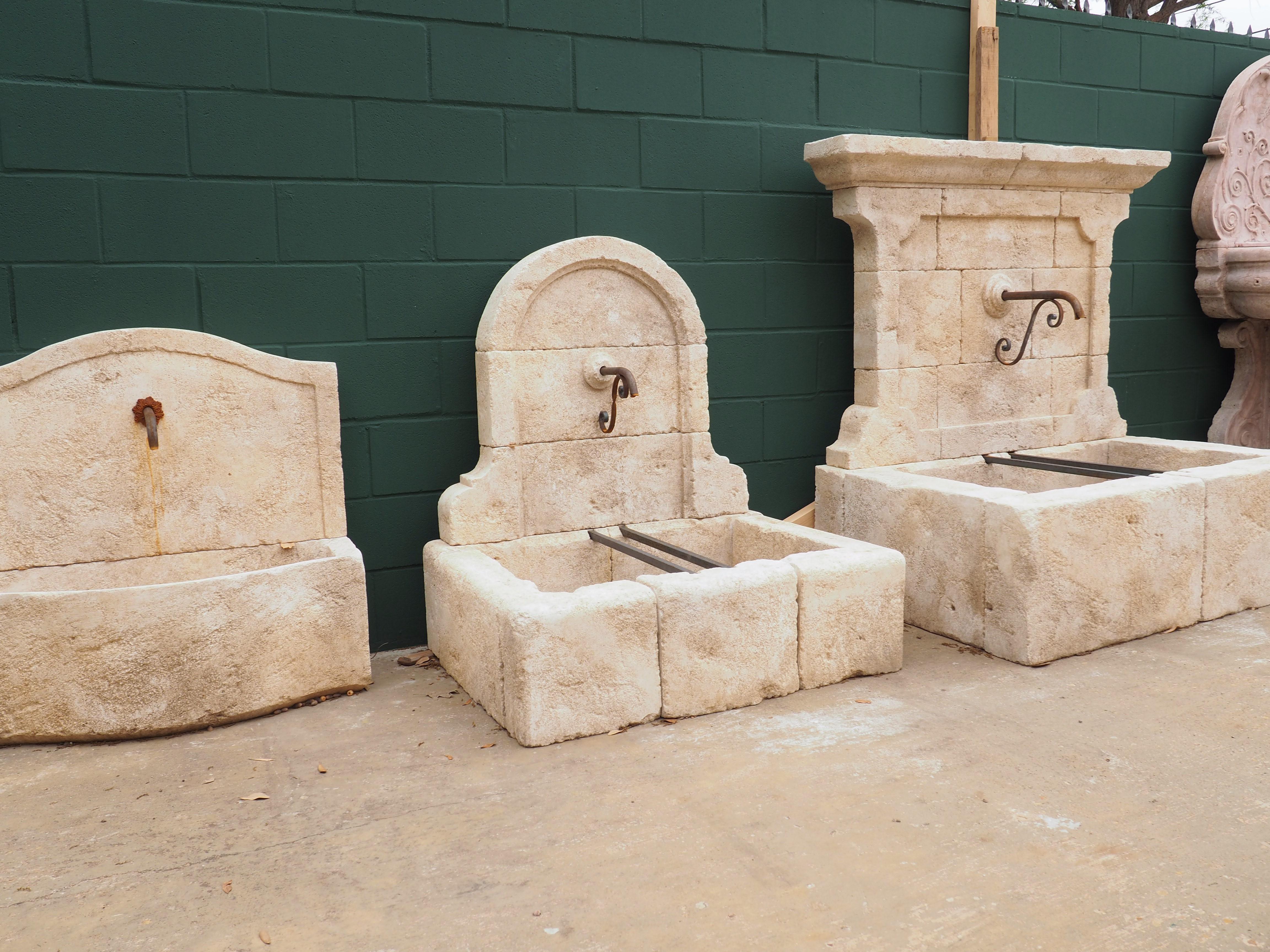 From Provence, France, this small limestone wall fountain has a high arched top with ogee carvings at the base of the wall. A thick molding with a chamfered edge adorns the interior of the wall, which is comprised of three stones. The middle stone