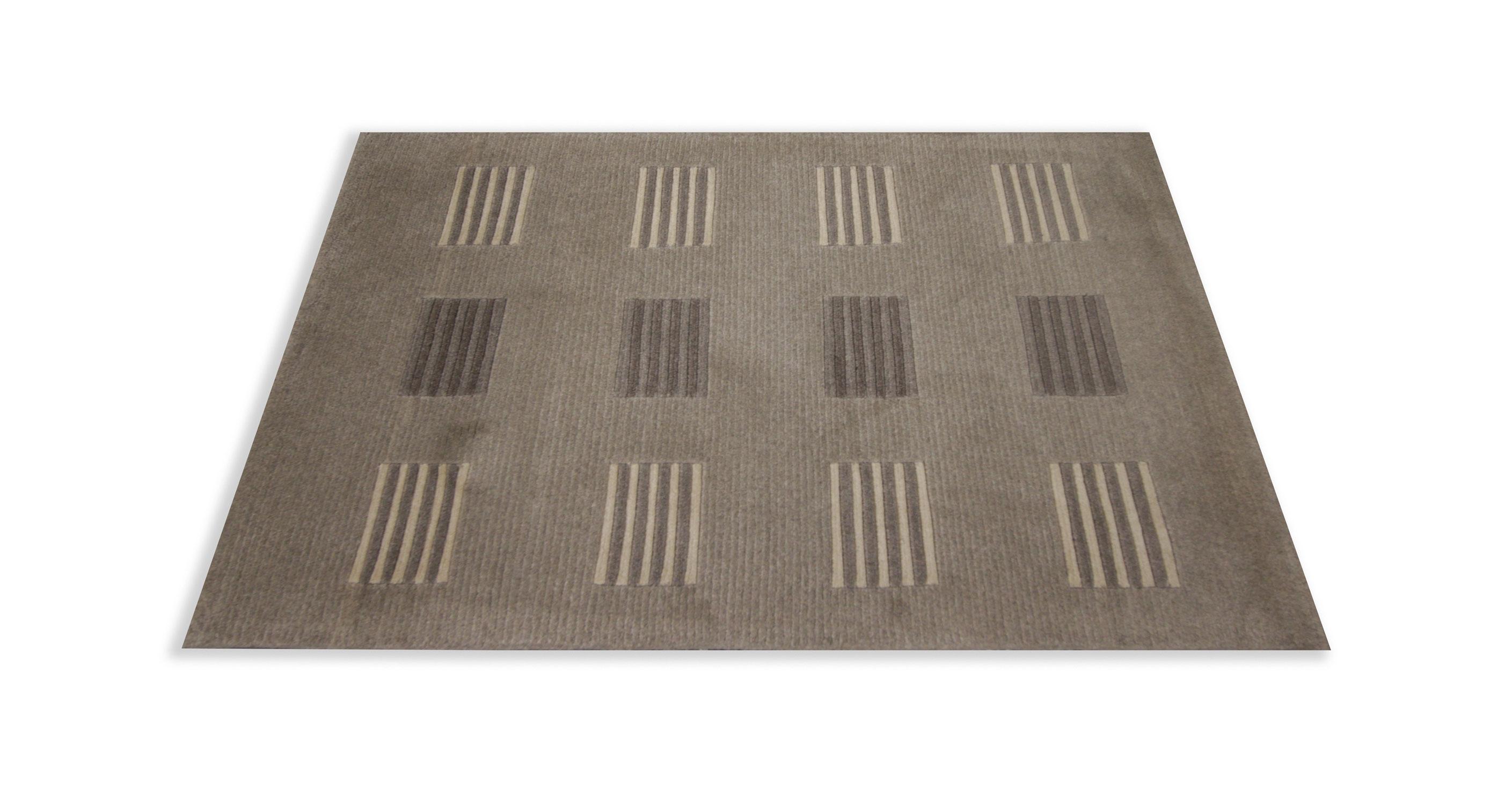 This fine wool mat is the perfect front or back door accessory. Woven by hand with fine wool and cotton that has been dyed with organic vegetable dyeing techniques. The design features a simple beige background with a modern square stripe design.