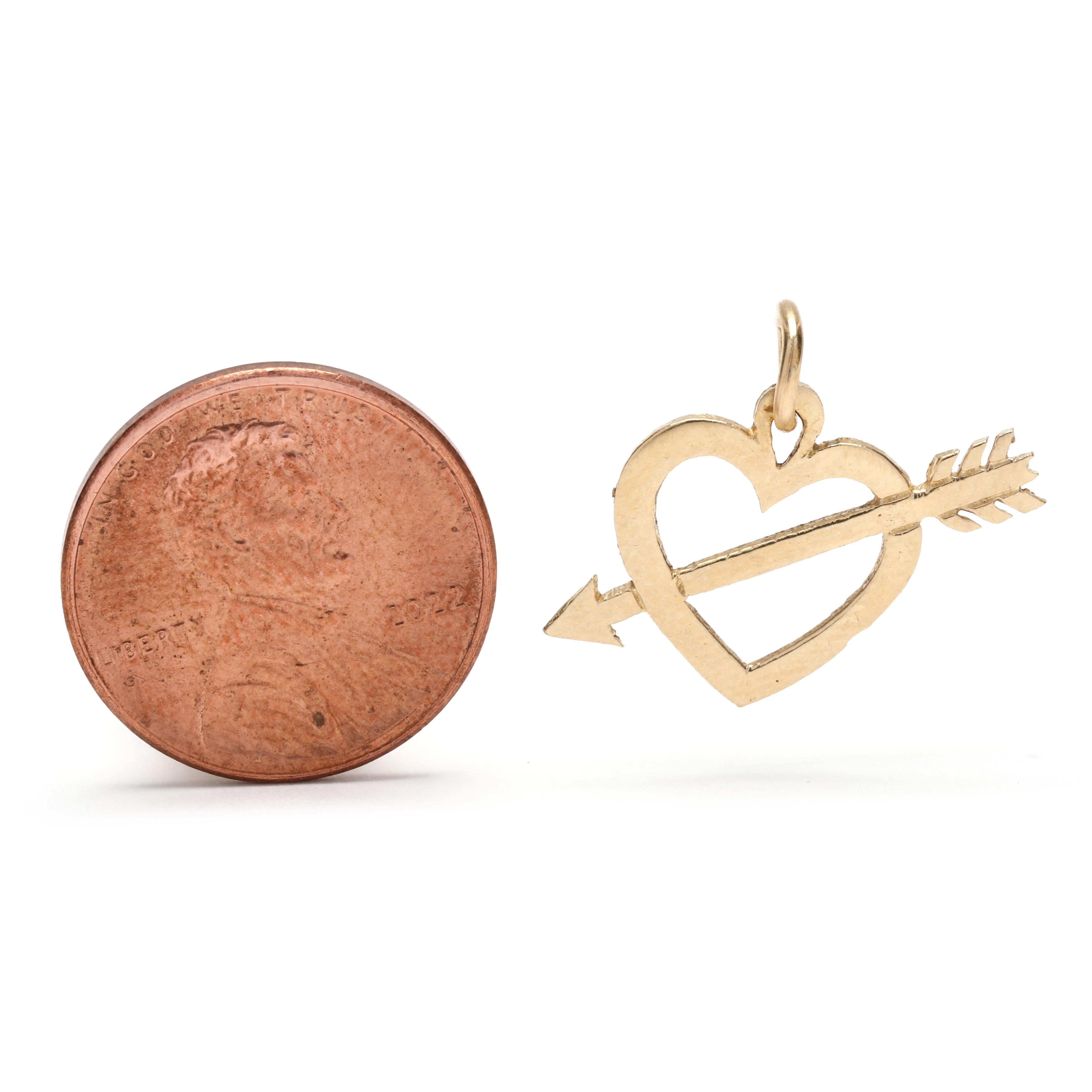 This 14K yellow gold small arrow heart charm is the perfect addition to any jewelry collection. The charm measures 5/8 inch in length and features a small heart with a tiny arrow piercing through it. This delicate charm is perfect for adding a