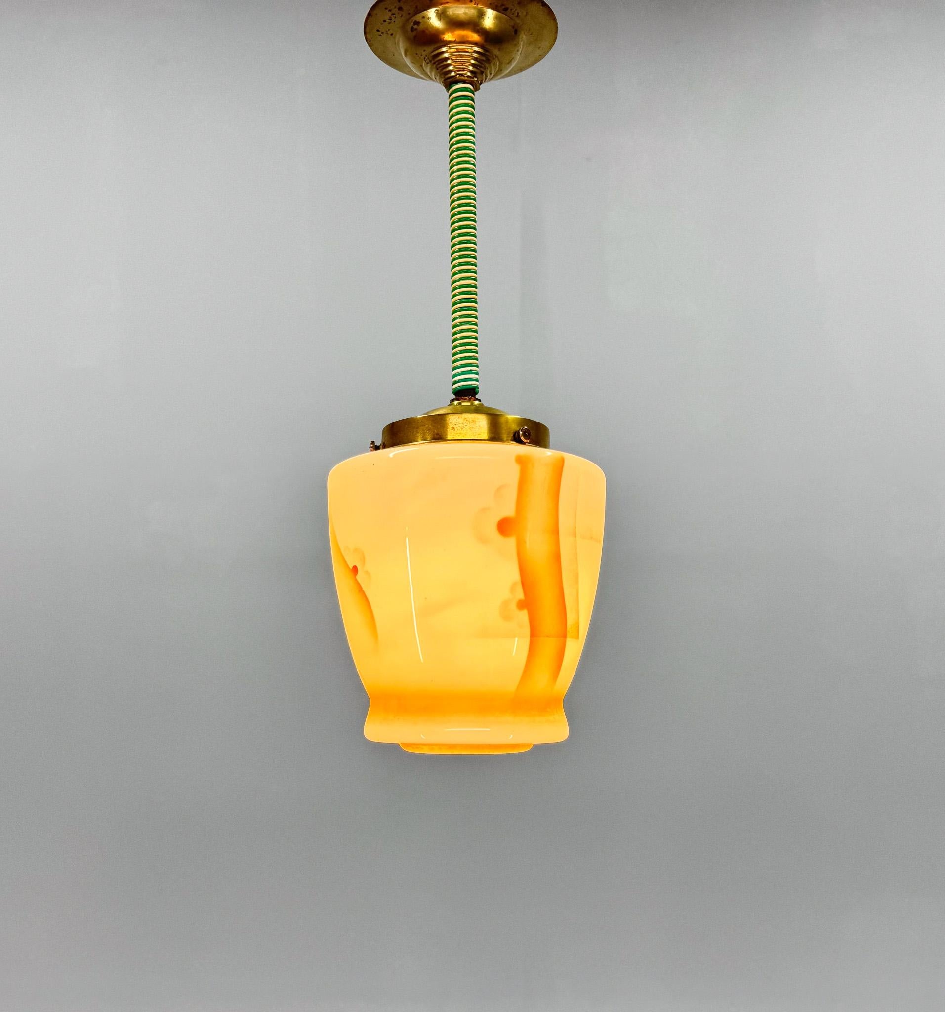 Petite et belle lampe suspendue art déco fabriquée en Allemagne dans les années 1930. Fabriqué en laiton et verre de lait peint. 
Câblage neuf, restauré. Ampoule 1 x E26 (E27). Compatible avec le câblage américain.
