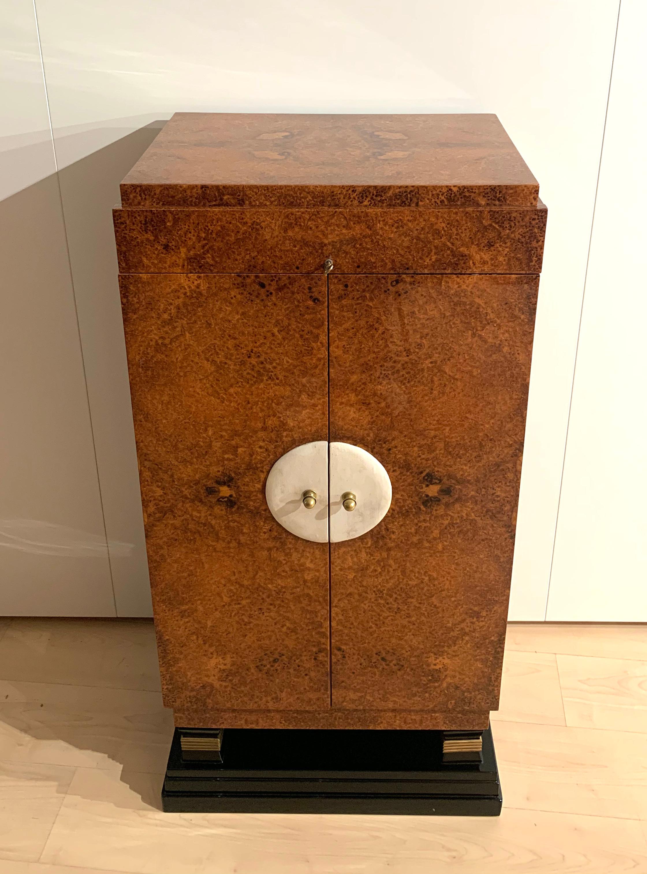 Beautiful, rare, small Art Deco Cabinet / Wardrobe, Amboyna Roos Veneer, leather and brass from France circa 1930

Lovely yellow-brown Amboyna Roots Veneer (loupe d'amboine), high-gloss clear lacquer finish. Original brass handles on white leather
