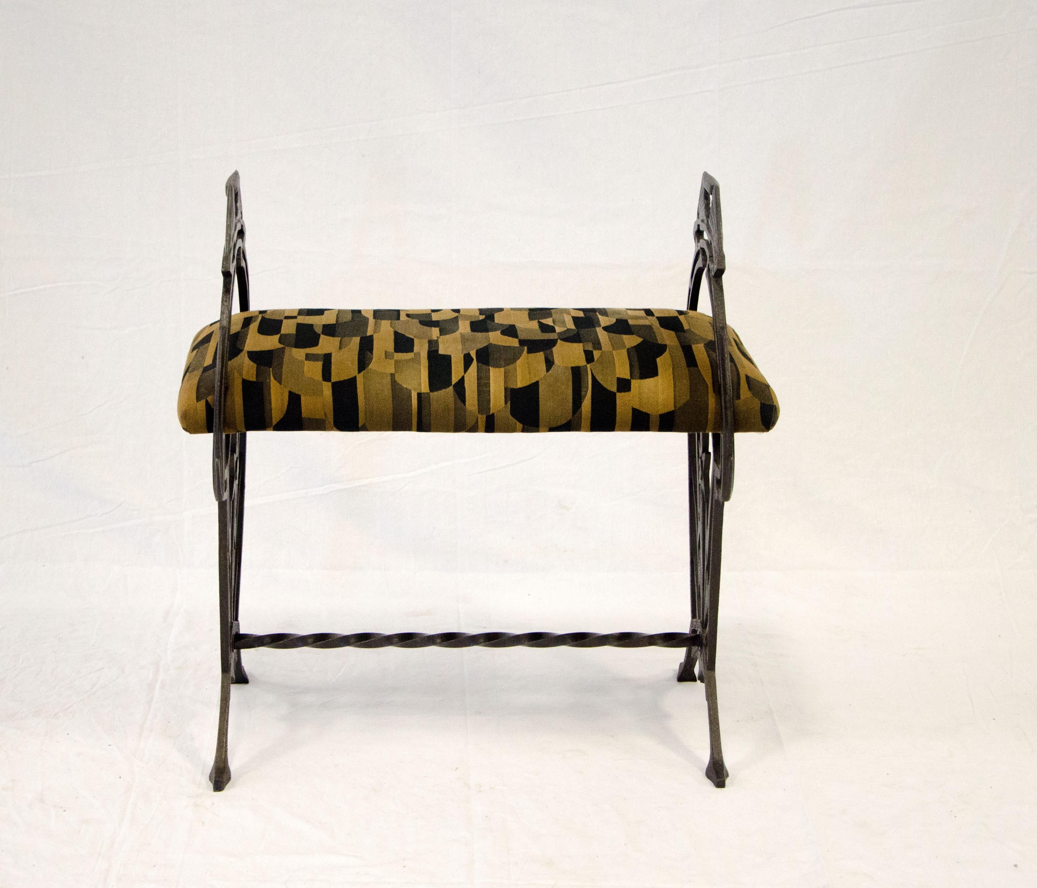 Nice Art Deco iron bench with an upholstered seat. It would be a good accent piece in a hallway or in a bedroom. The Art Deco themed fabric has one slightly darker stain spot about the size of a nickel and is mostly only visible on close inspection.