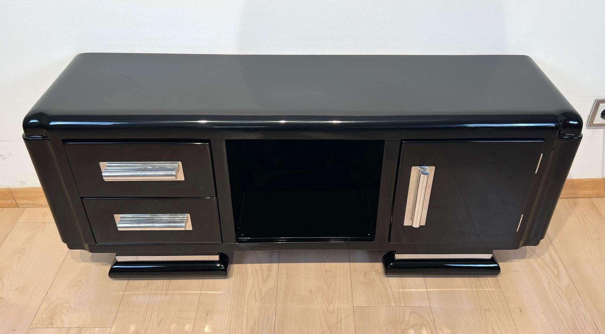 Petite Art Deco lowboard / low sideboard / TV board from Italy about 1940.
Walnut Veneer on softwood. black piano lacquer finish in six layers and high-gloss polished. Left 2 drawers, center 1 free compartment, right 1 door. Doors and drawers