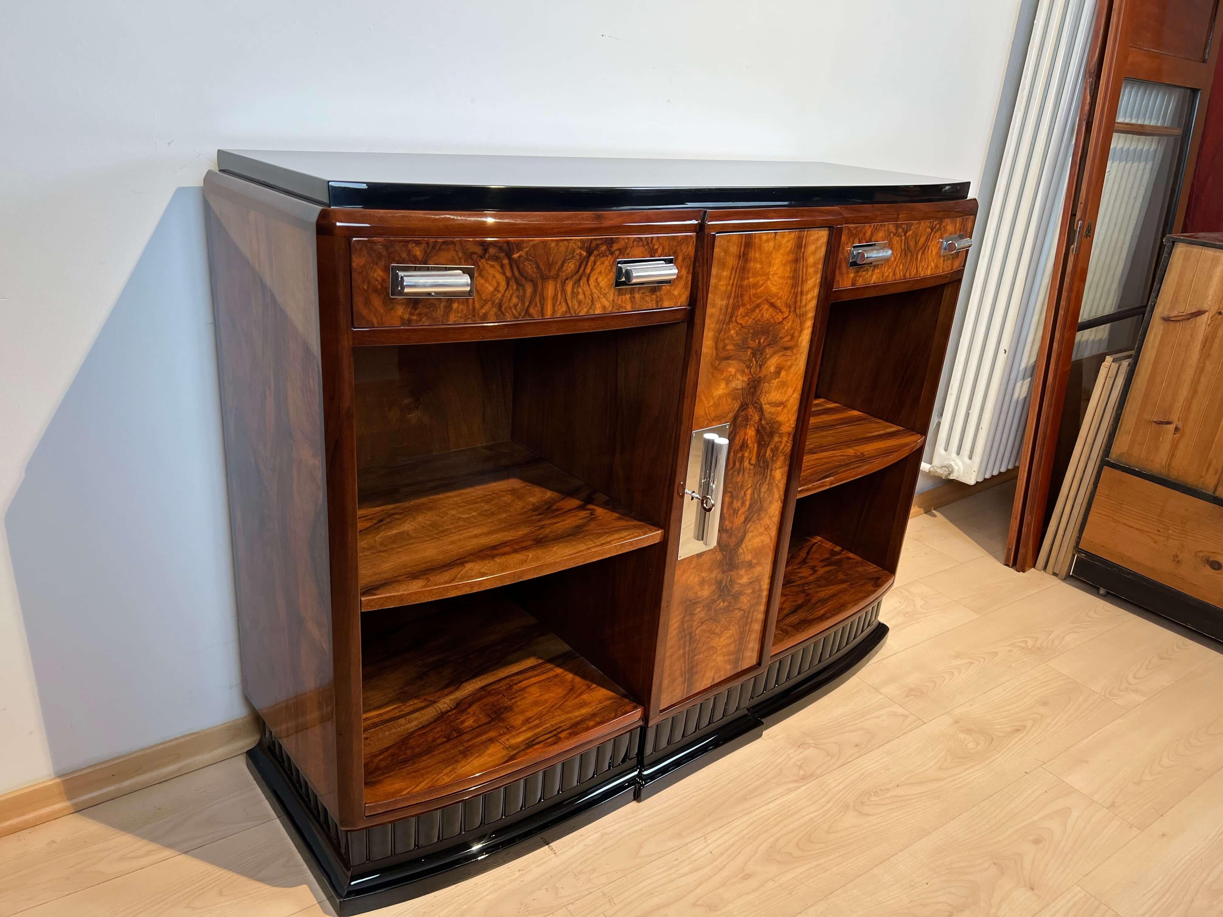 Small Art Deco Sideboard with Open Shelf / Cupboard in Walnut Veneer and black lacquer from France about 1930.

Walnut veneered and solid, partly ebonized. Lacquered high gloss surface. Above with black lacquered wooden plate. Chromed and polished