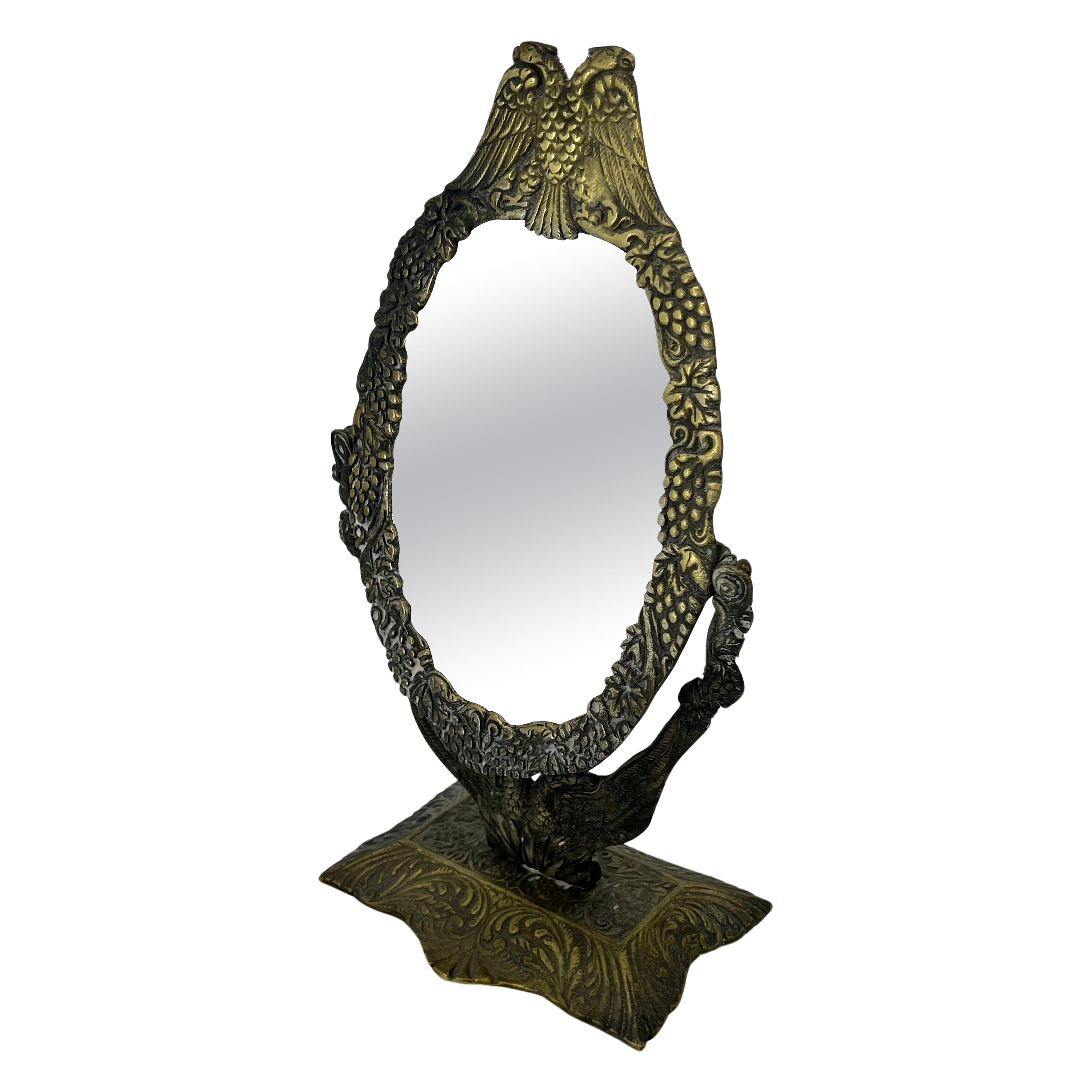 Piccolo specchio da toilette in bronzo con doppia aquila e decorazione floreale su base rettangolare.
Lo specchio potrebbe essere russo, francese o austriaco.