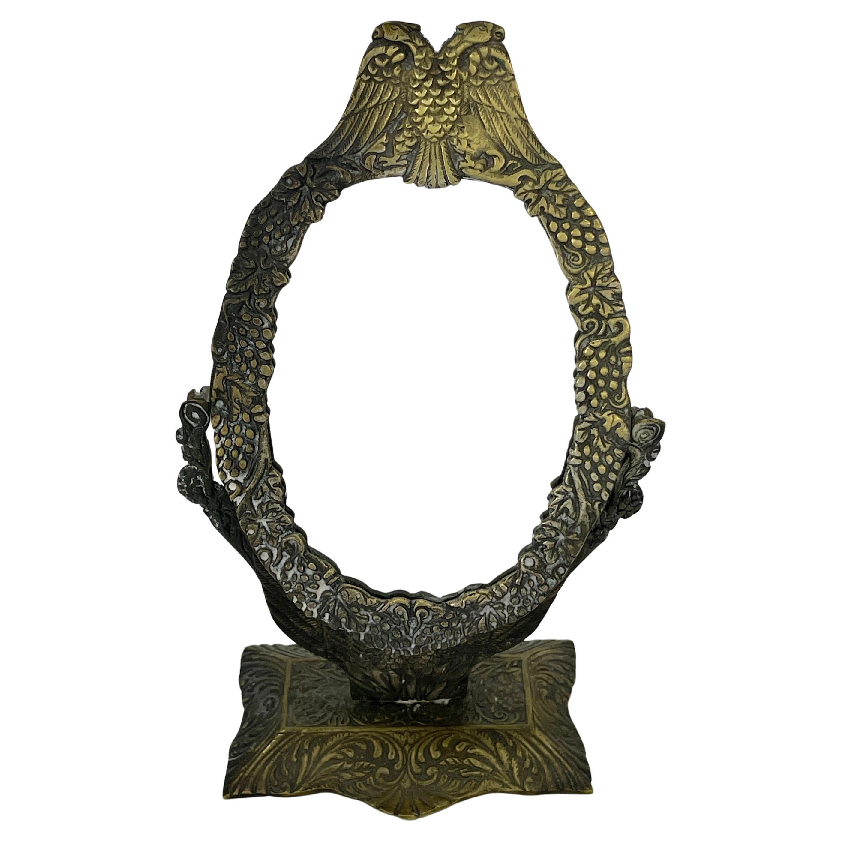 Petit miroir de courtoisie en bronze avec aigle double et décoration florale sur une base rectangulaire.
Le miroir peut être russe, français ou autrichien.