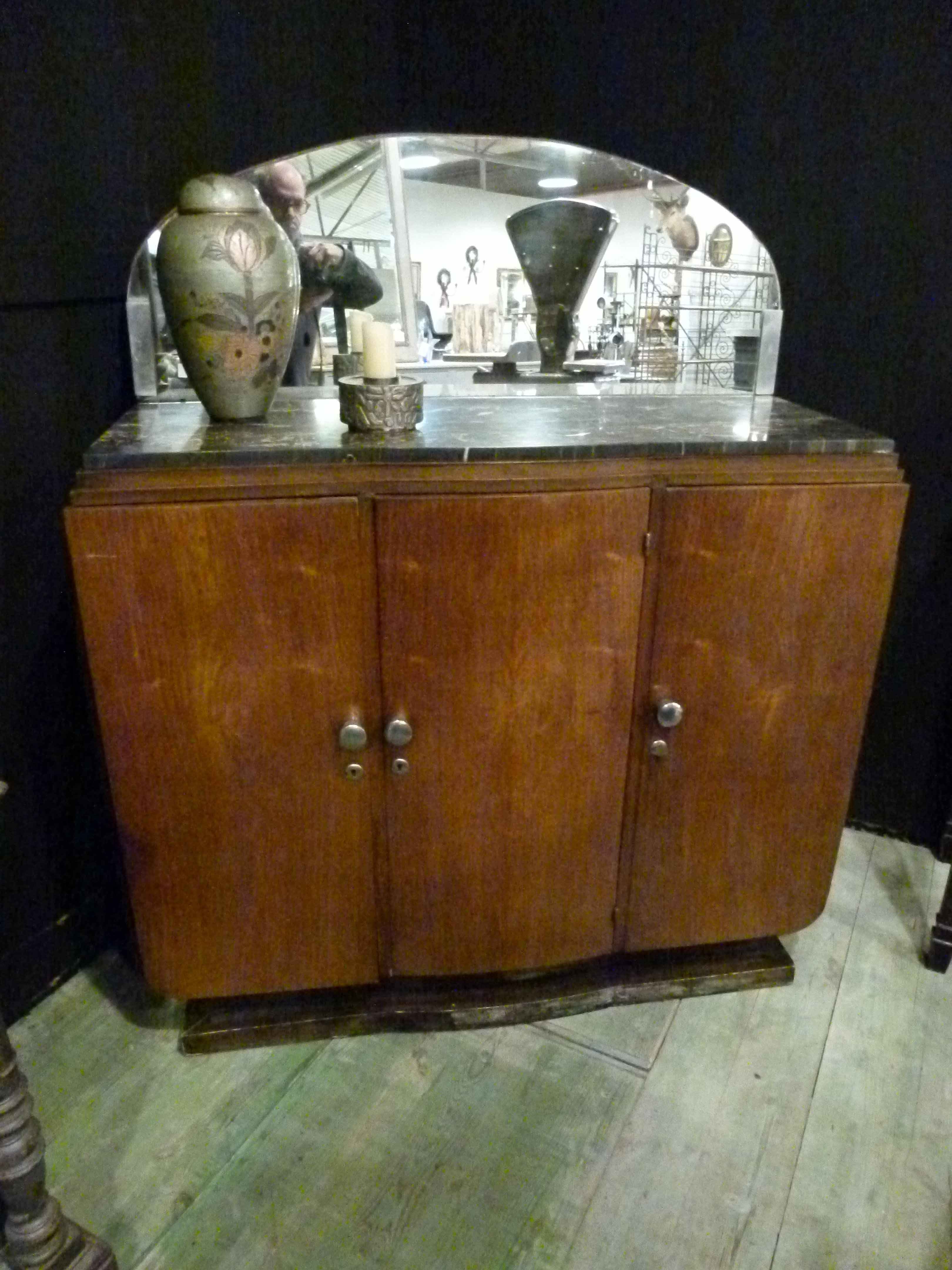 Small Art Deco walnut and marble French buffet with a crescent moon shaped mirror incorporated on the top.
The buffet comprises three frontal doors that open to three shelves in the interior. A black marble with mirror complete this very special
