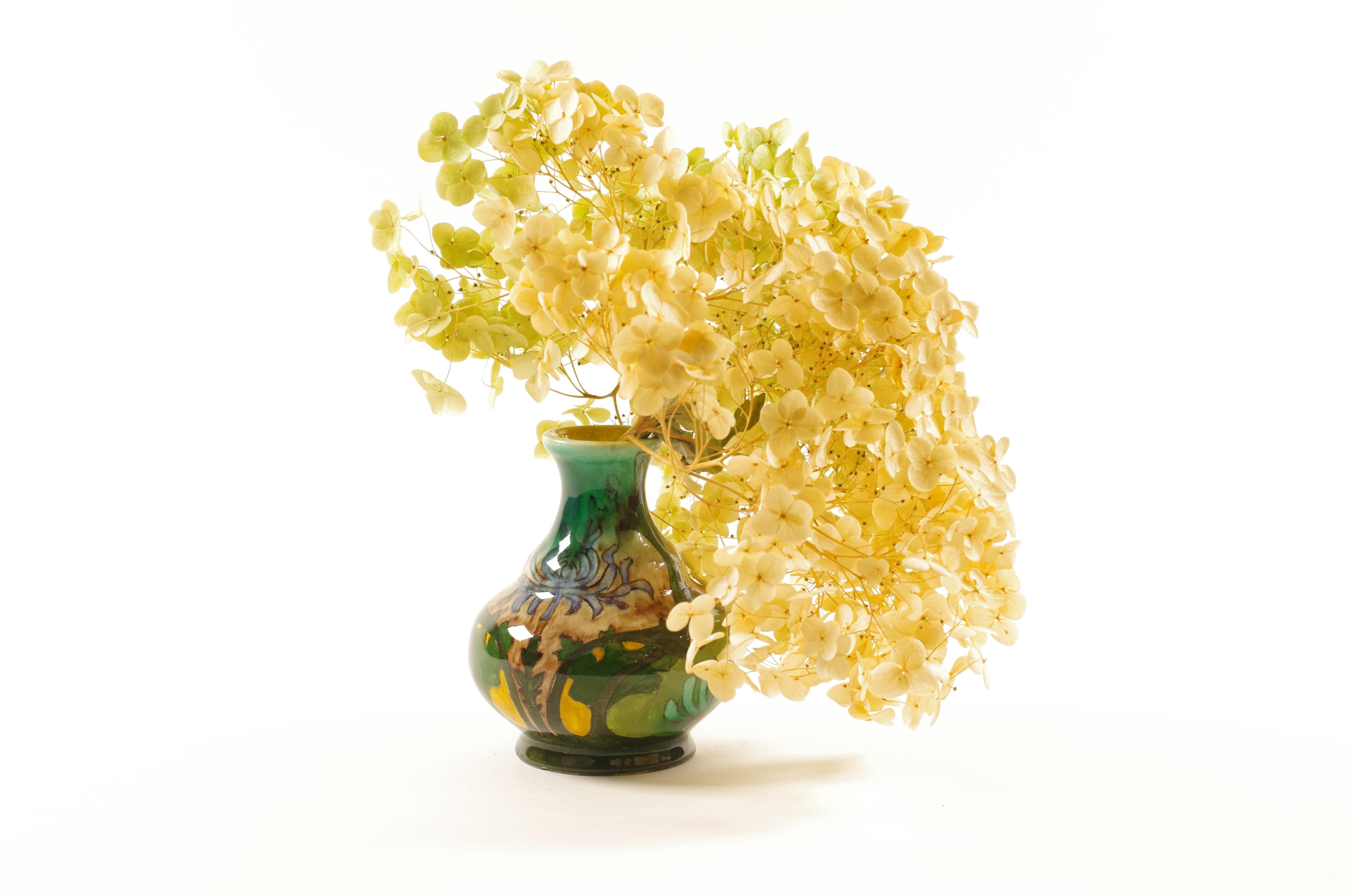 Rare petit vase Art nouveau produit par S.S.A. Brantjes & Co. à Purmerend, Pays-Bas, entre 1895 et 1904. Ce modèle, n° 1100, présente le très recherché décor A, caractérisé par des formes organiques fluides et des motifs végétaux peints à la main