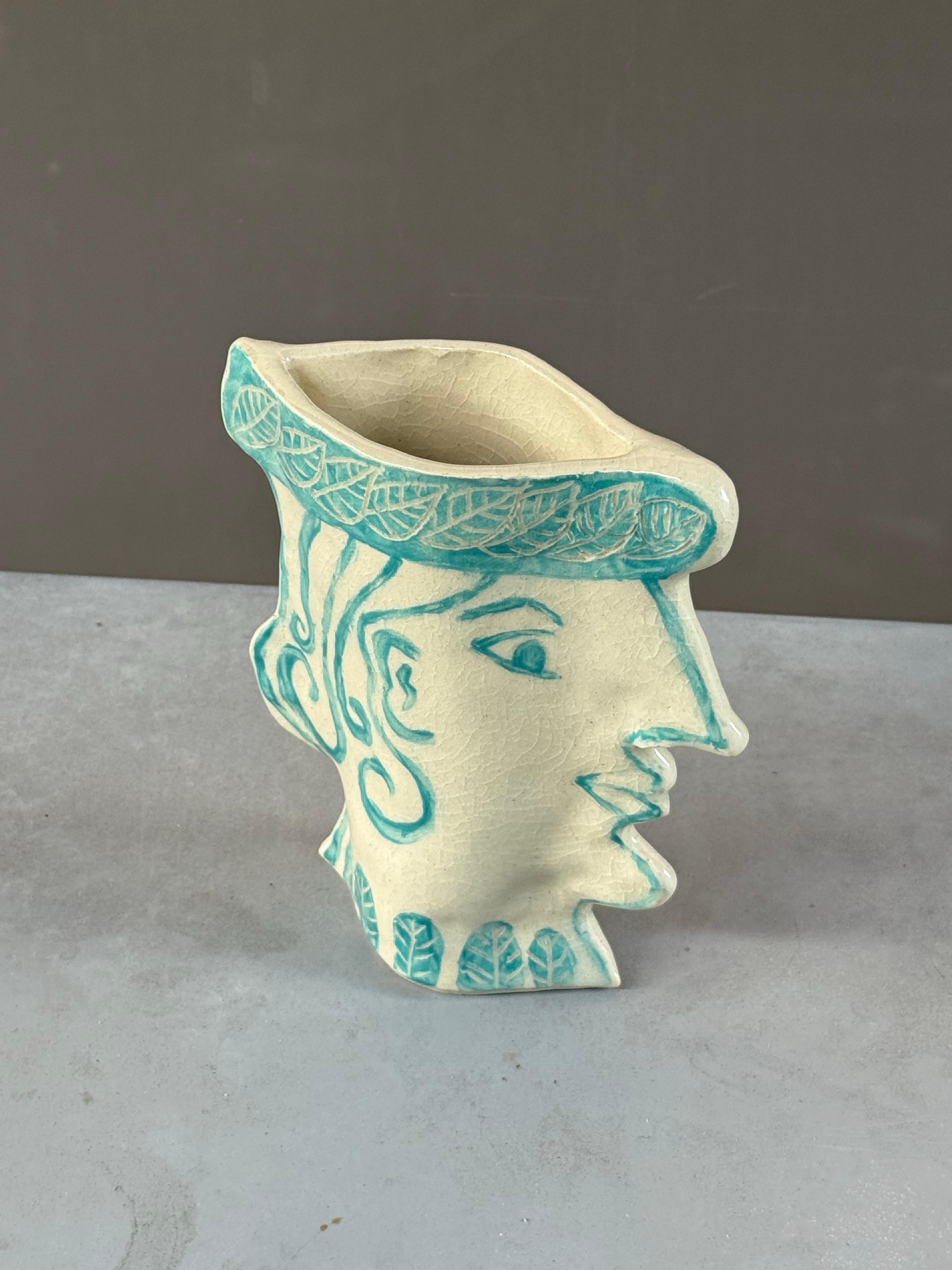 Piccolo vaso dal volto femminile di Susanne Portanova 

Un mix di vecchio mondo e tecnica new age. Design altamente scolpito realizzato in gres, dipinto sottosmalto su argilla dura e pelle e smalto trasparente, cotto in forno a 6°. Il pezzo è di