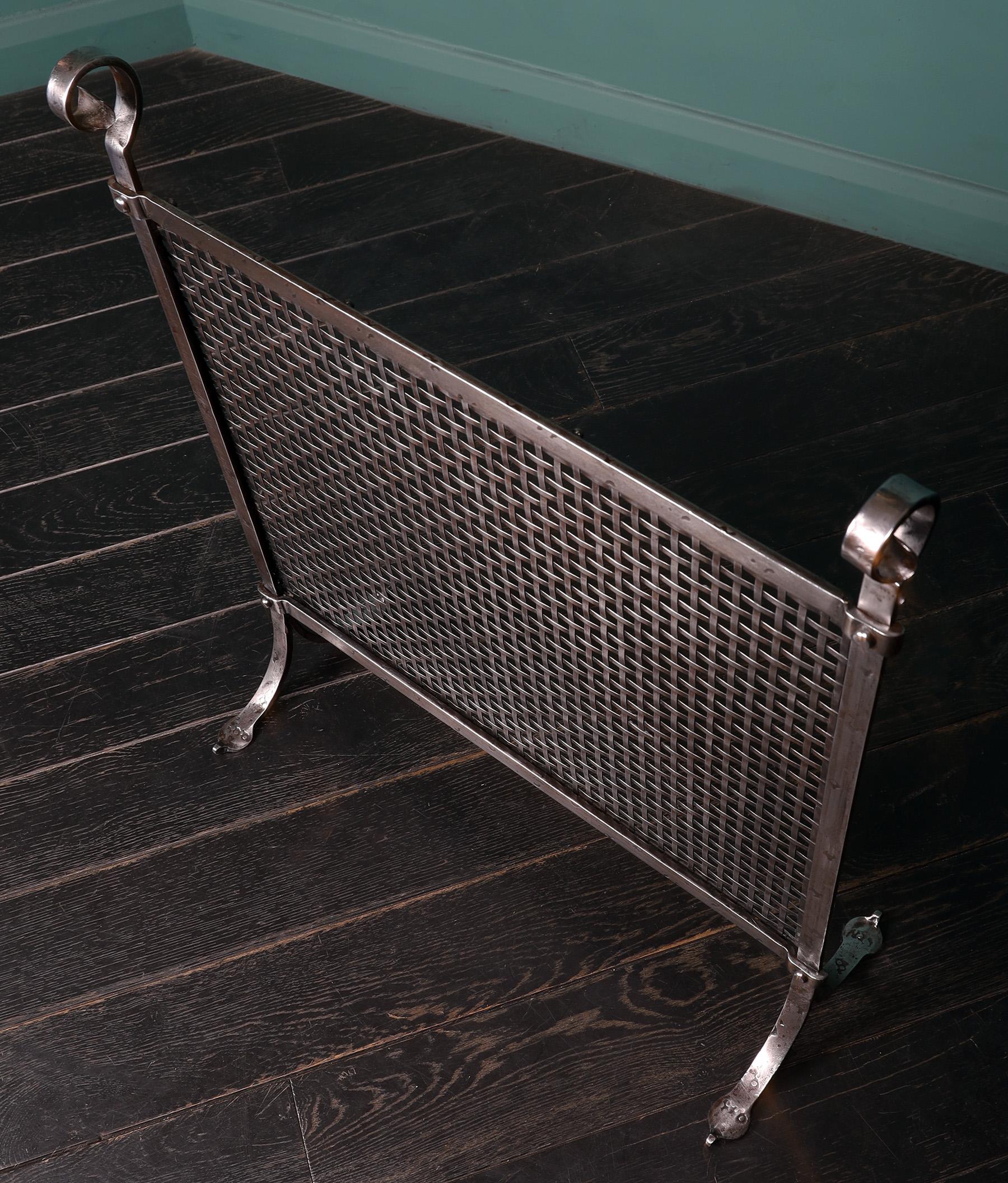 A small charming Arts & Crafts polished steel lattice-work fire screen with flat-weave mesh, riveted frame and scrolled finials uppermost. Restored.
Circa 1900