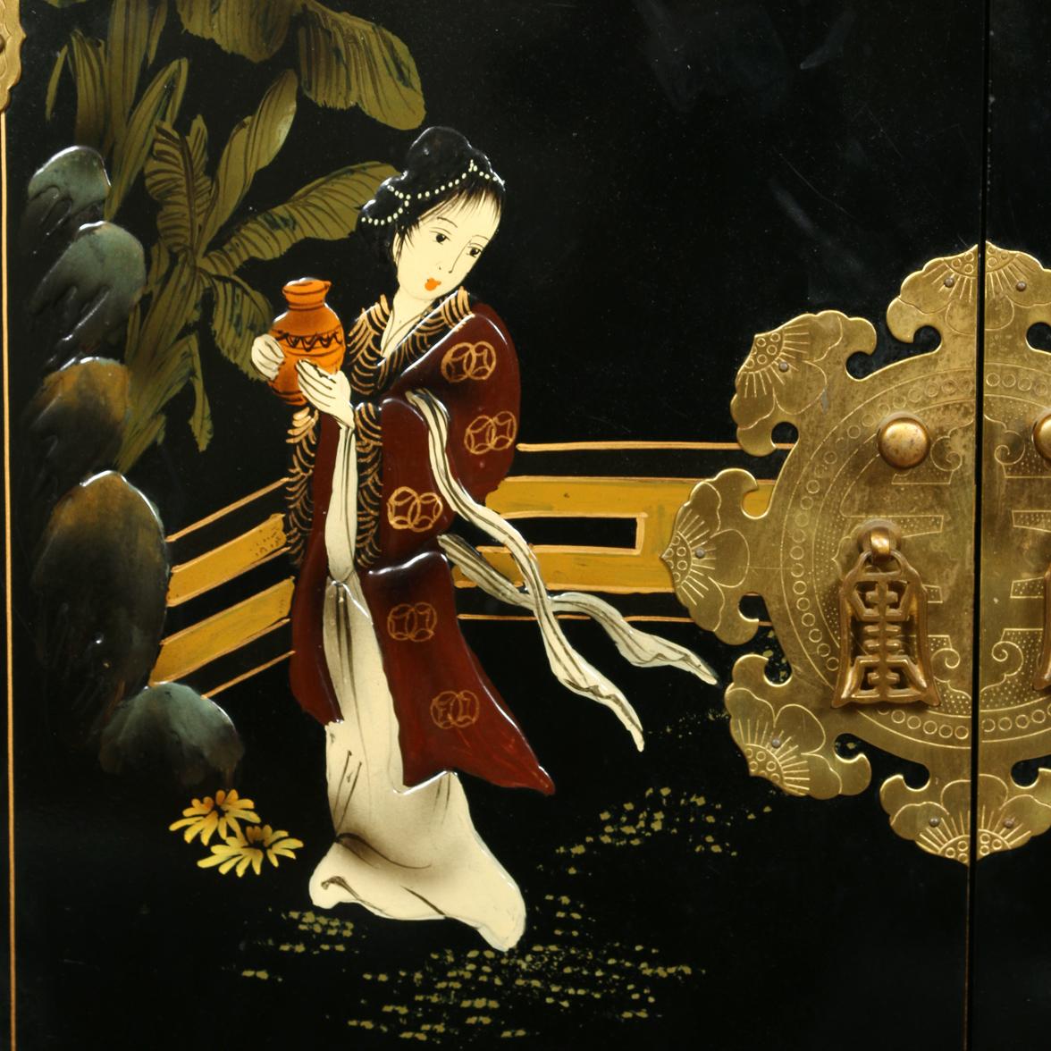 Small Asian chinoiserie painted black cabinet with two doors and brass hardware.