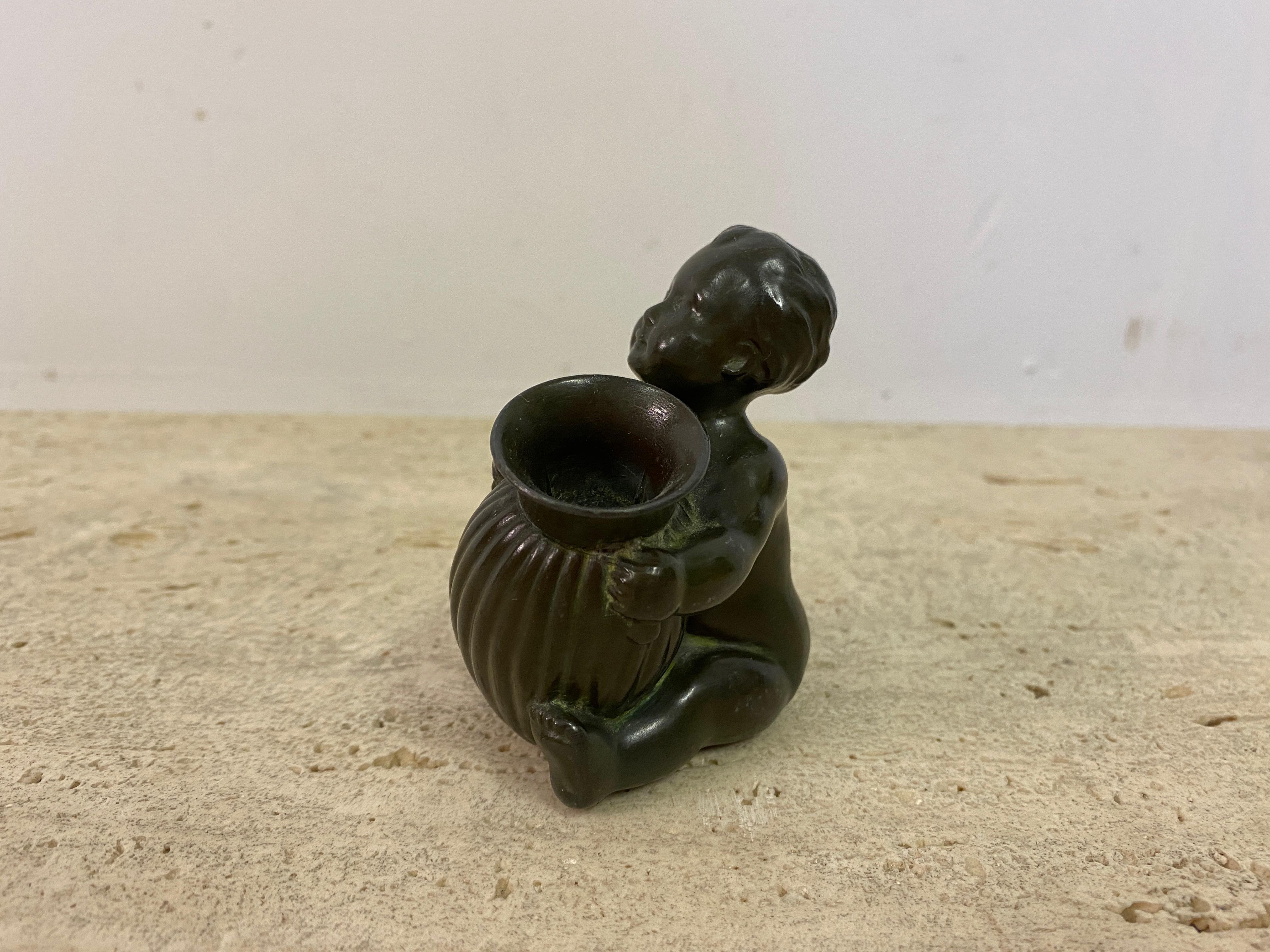 Small Baby figurine holding a vase

By Just Andersen

Vase acts as a pen holder

Made from disco metal

Stamped underneath

Denmark 1930s.