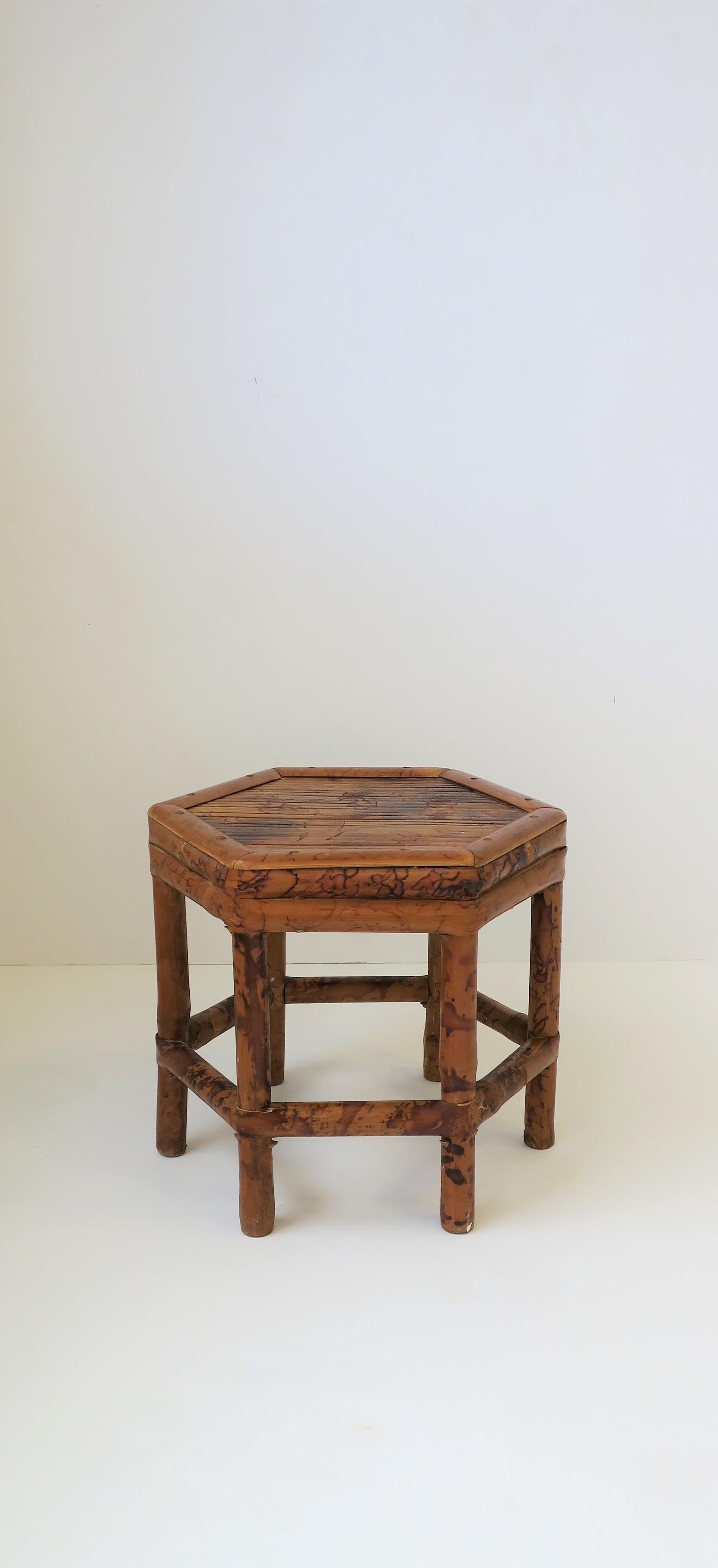 A small, low, bamboo pedestal side or drinks table or plant stand, circa 1970s. Table has a 'hexagon' shape, which is a nice alternative to round or square. A great piece to hold a drink, books, pant etc. Piece is a convenient size too, measuring: