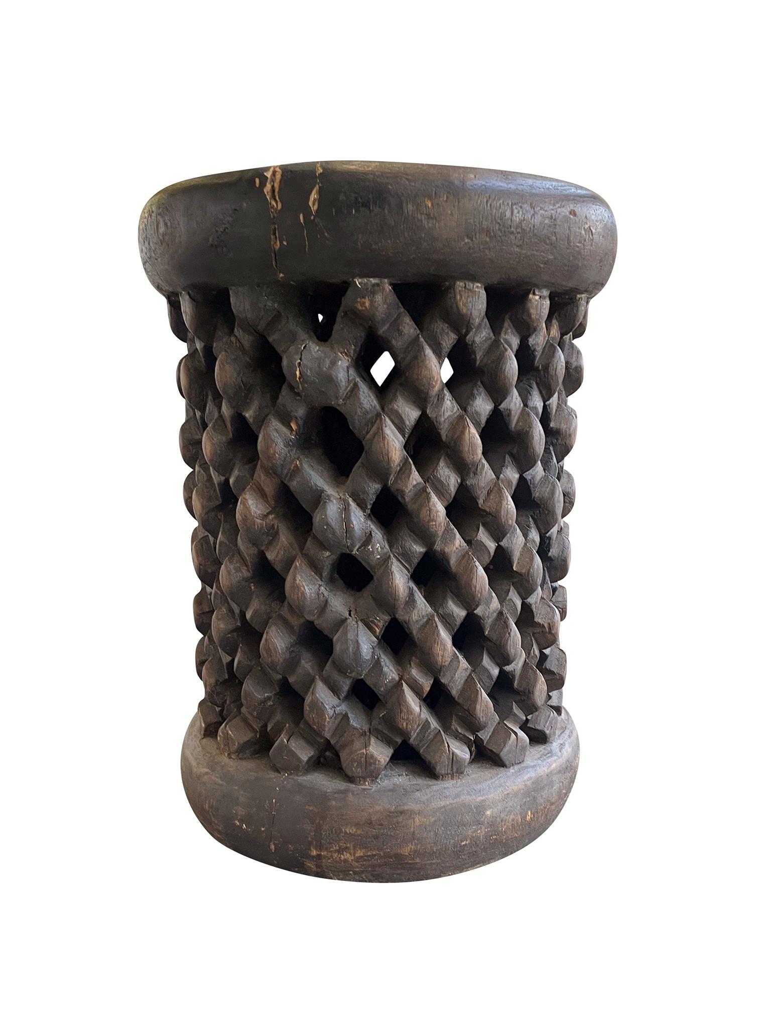 Hand-carved wood Bamileke table from Cameroon, mid-late 20th century. The body of the table is intricately carved with a lattice-like design. We love the smoothed edges of the top and the overall organic textures and tone of the