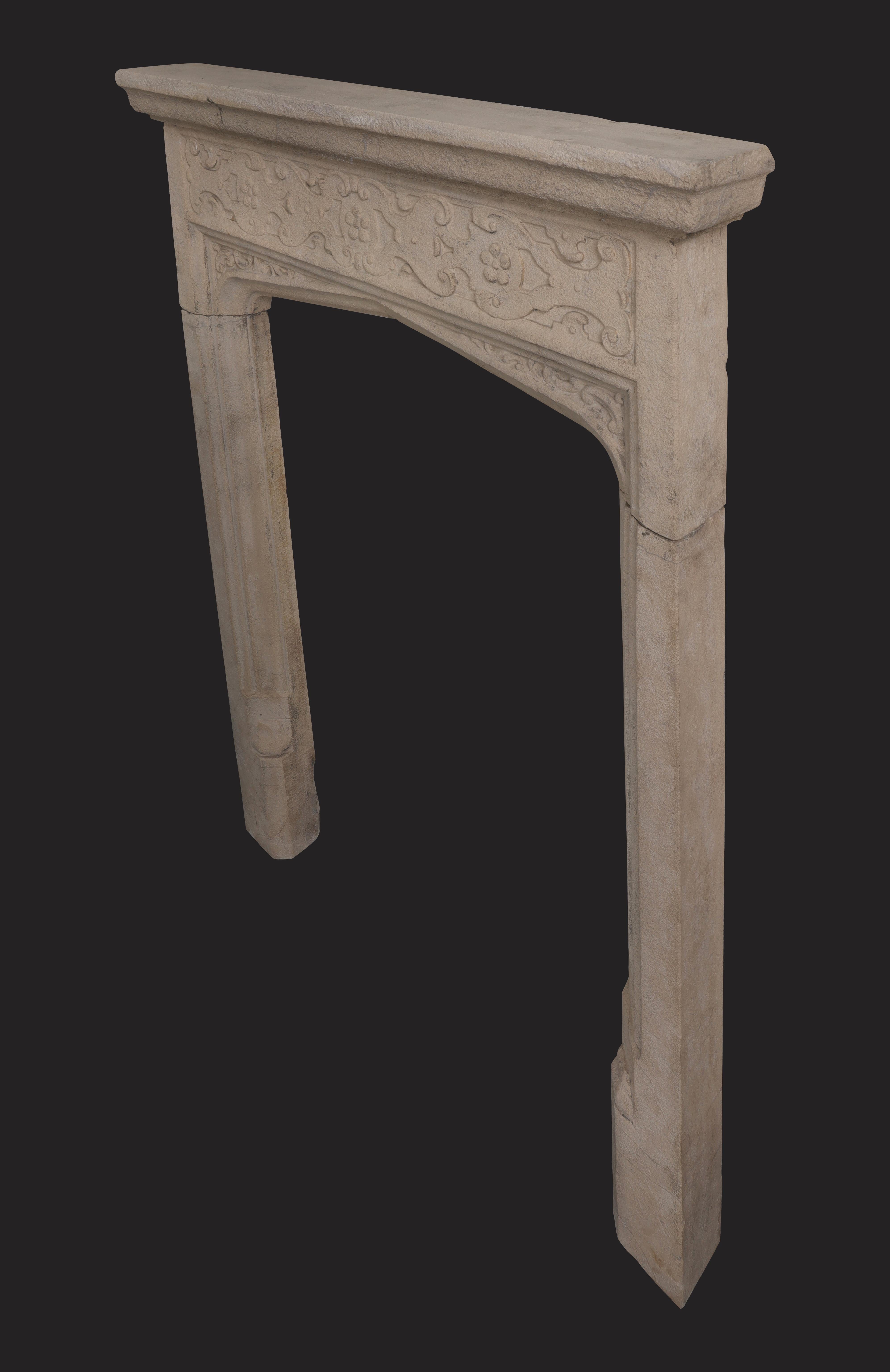 A small Bathstone chimneypiece in the Jacobean manner. Beautiful scrolled strapwork with rose detail adorn the frieze. Scroll decoration framed within the fluted spandrel archs. Fluting and plinth carved detail to jambs. 
Internal width: 27 1/4″