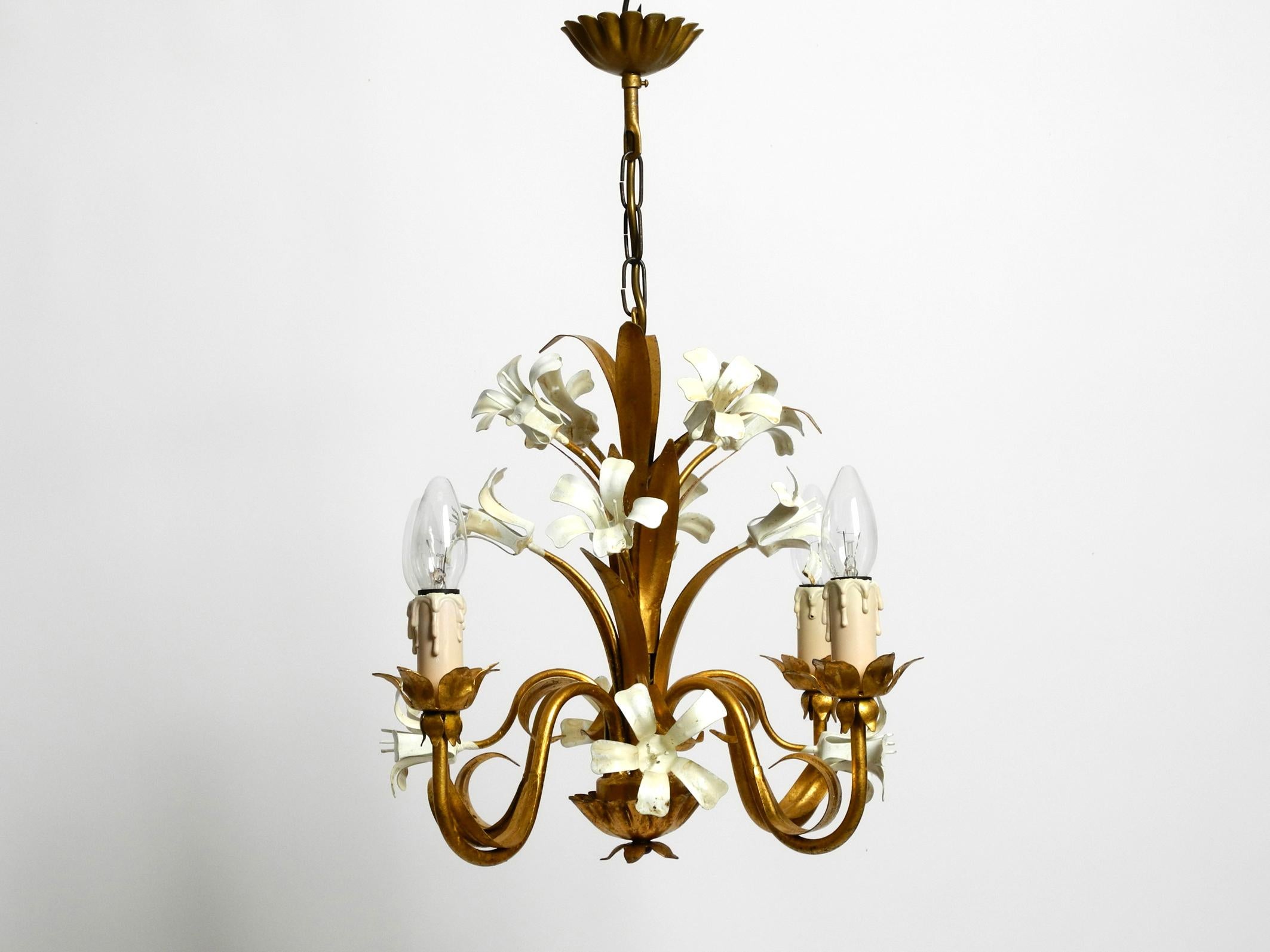Small beautiful 1960s gold-plated 4-arm metal chandelier.
Very nice, elaborate design with lots of details.
Entire lamp is made of heavy gold plated metal.
The flowers are painted in creamy white. One E14 socket each. Fully functional and 100%