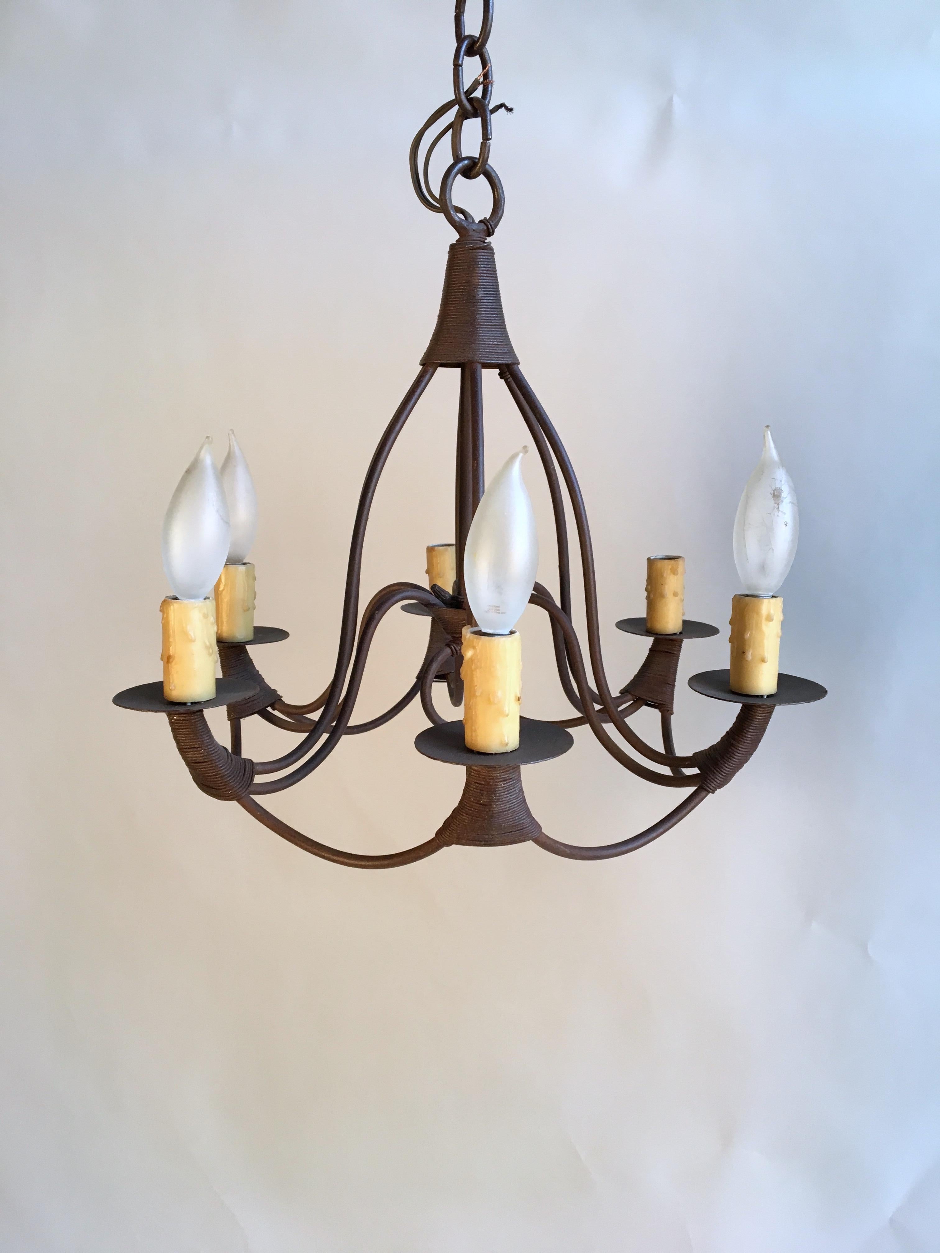 A small French Country 6 candle bell-form chandelier in iron retailed by Pierre Deux, in rusted finish.