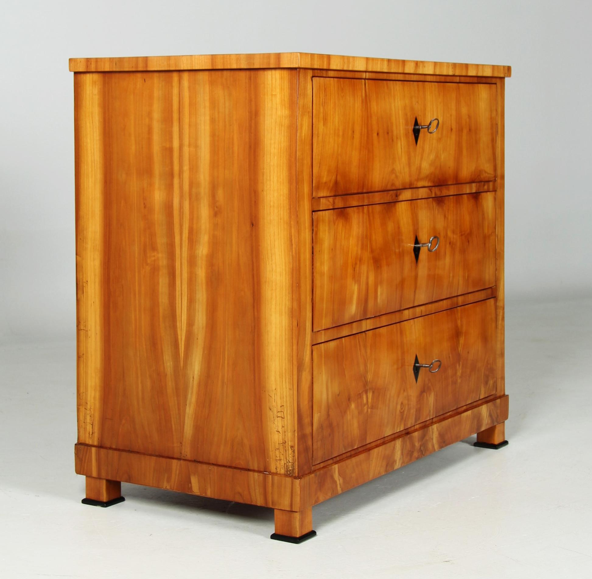 Small antique chest of drawers from the southern German Biedermeier period circa 1820-1830.

Dimensions: H x W x D: 86 x 91 x 51 cm

Strictly cubist piece of furniture standing on square feet with small black plinths.
The symmetrically laid cherry