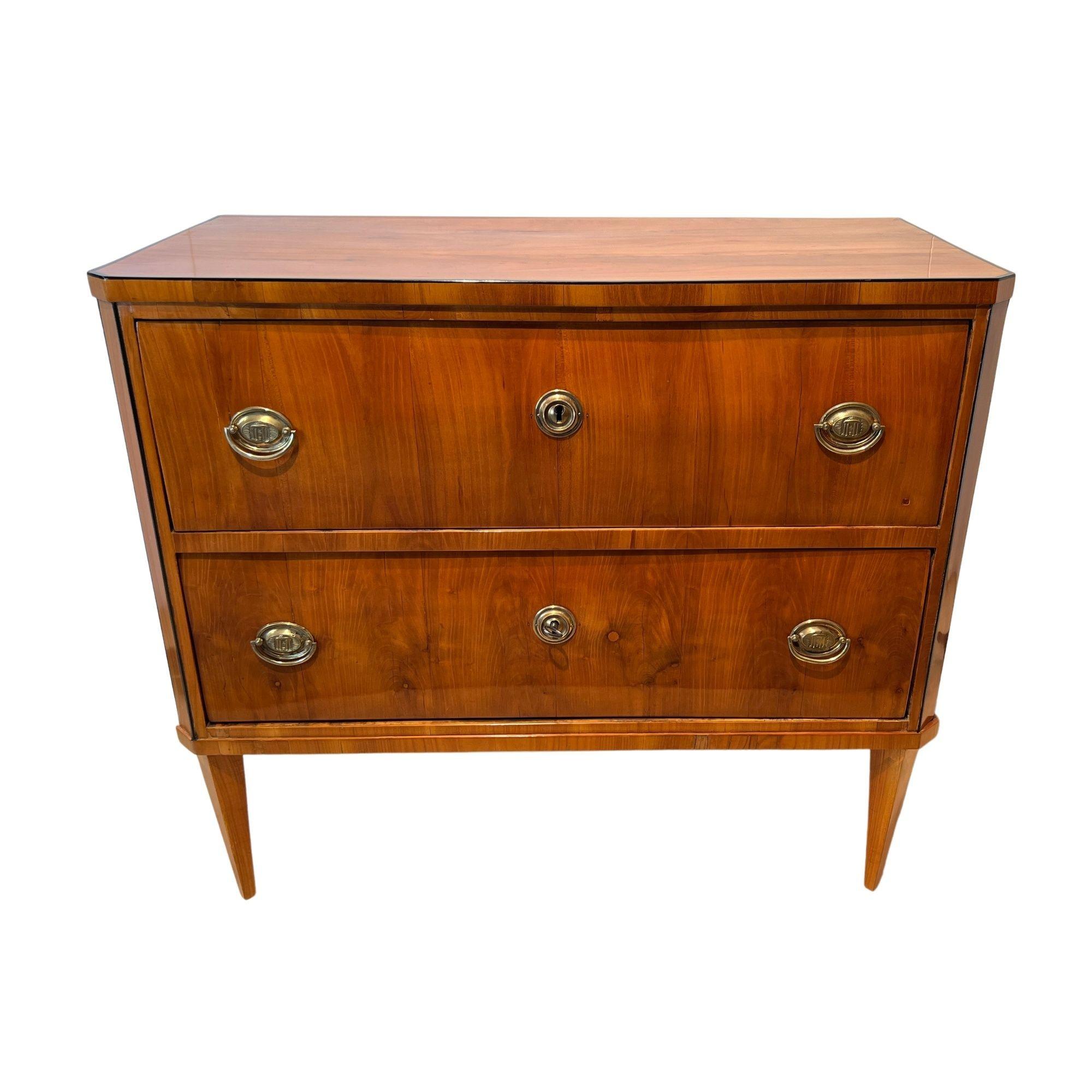 Fine, small Empire / early Biedermeier Commode or Chest of Two Drawers from South Germany around 1820.
Cherry veneered on softwood and solid cherry wood. Ebonized decorative trims. Original brass fittings and iron locks.
Restored condition, hand