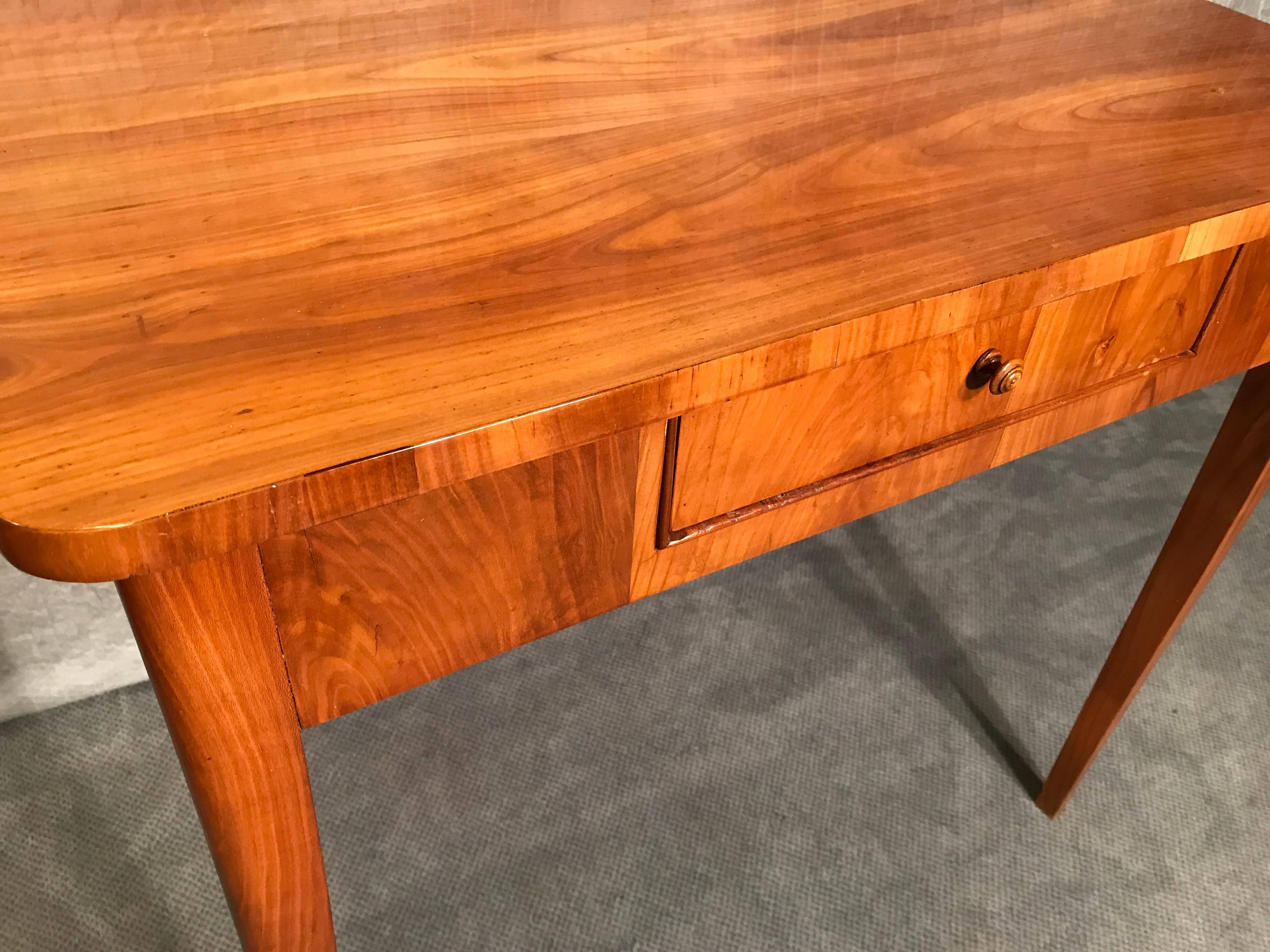 Small Biedermeier desk or side table, Germany 1820,
The desk has a beautiful cherry veneer. It has one drawer in the front. 
You do not need to put it against a wall because the back has the same cherry veneer as the front. It is the perfect little