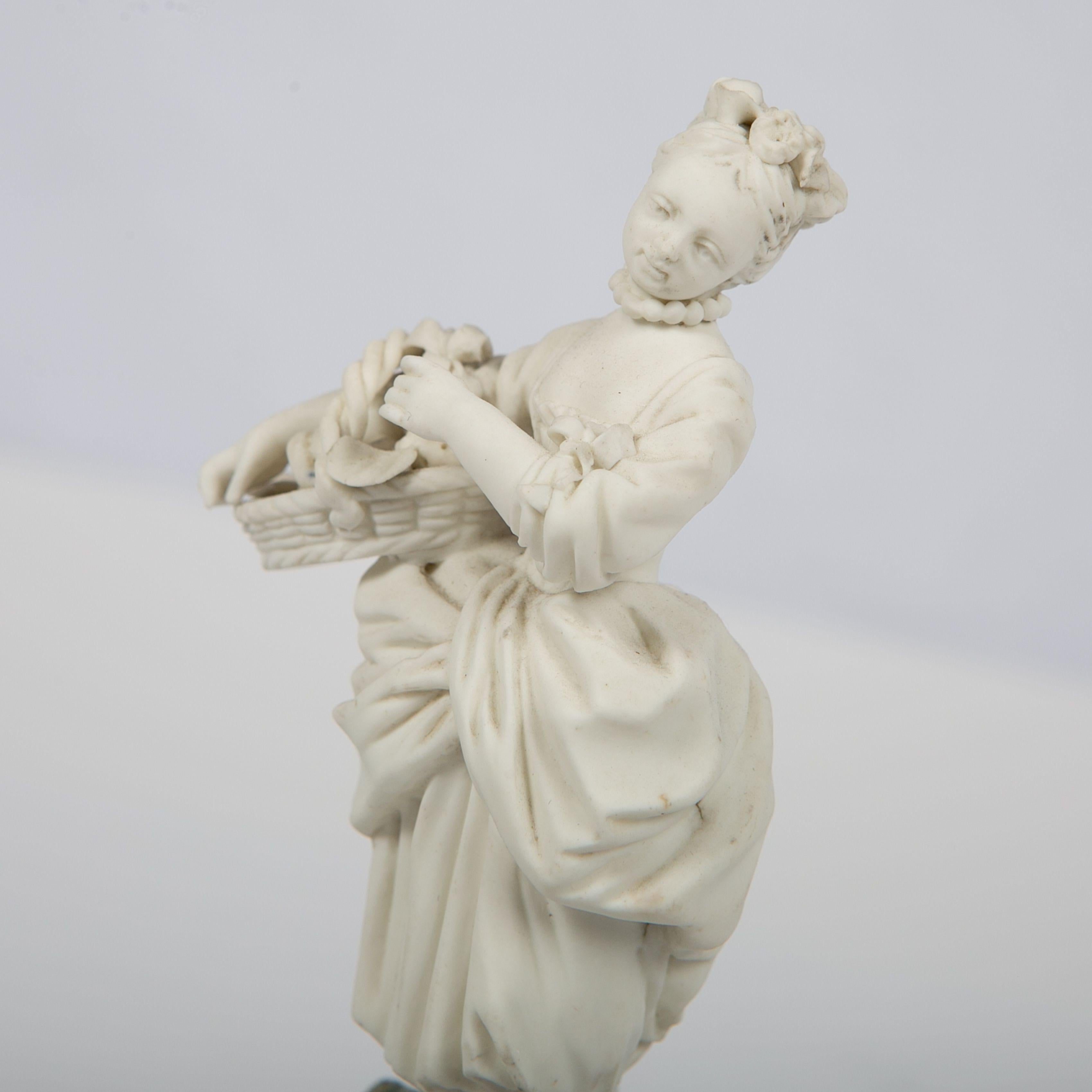The Mennecy factory made this small and delicate figure of a girl, circa 1770. She is wearing a period costume and holding a basket of fruit. Made of bisque porcelain, the figure is not painted. This allows us to see the details of the model quite