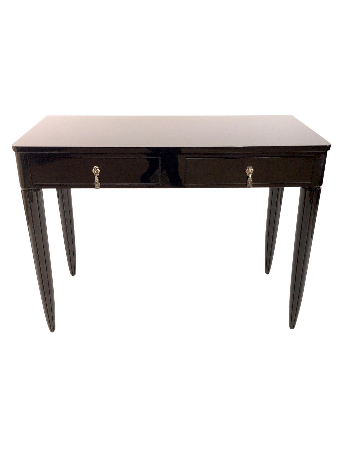 This early French Art Deco, circa 1925 could be used as a console in the entrance, too. 
The little desk has two drawers with typical fittings for this glamorous era. 
High gloss black piano lacquer 
Channeled table-legs.