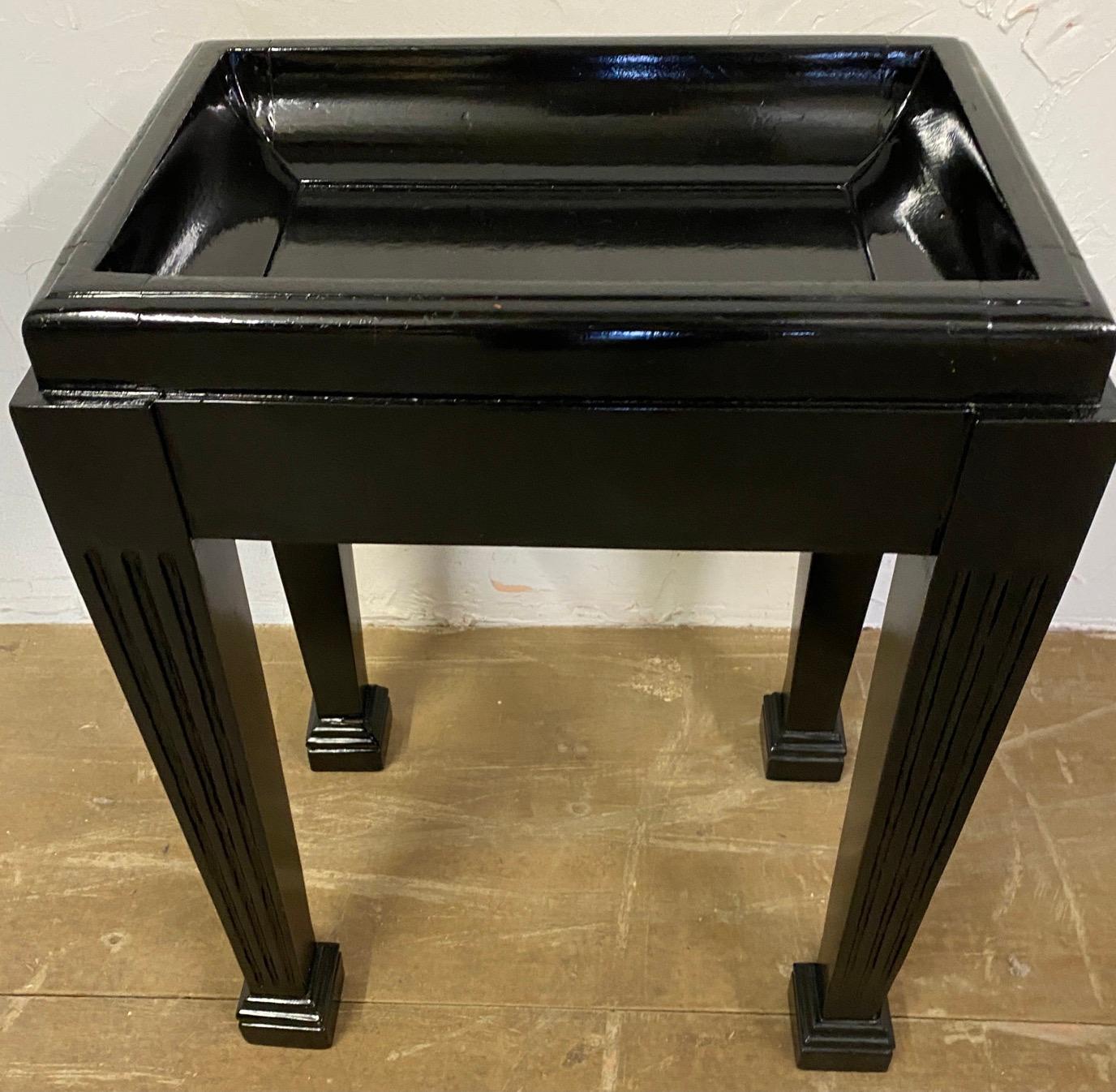 Small lacquered stand with an indented top for holding various trinkets or decoration. Can be useful as a small side table or end table or plant stand.