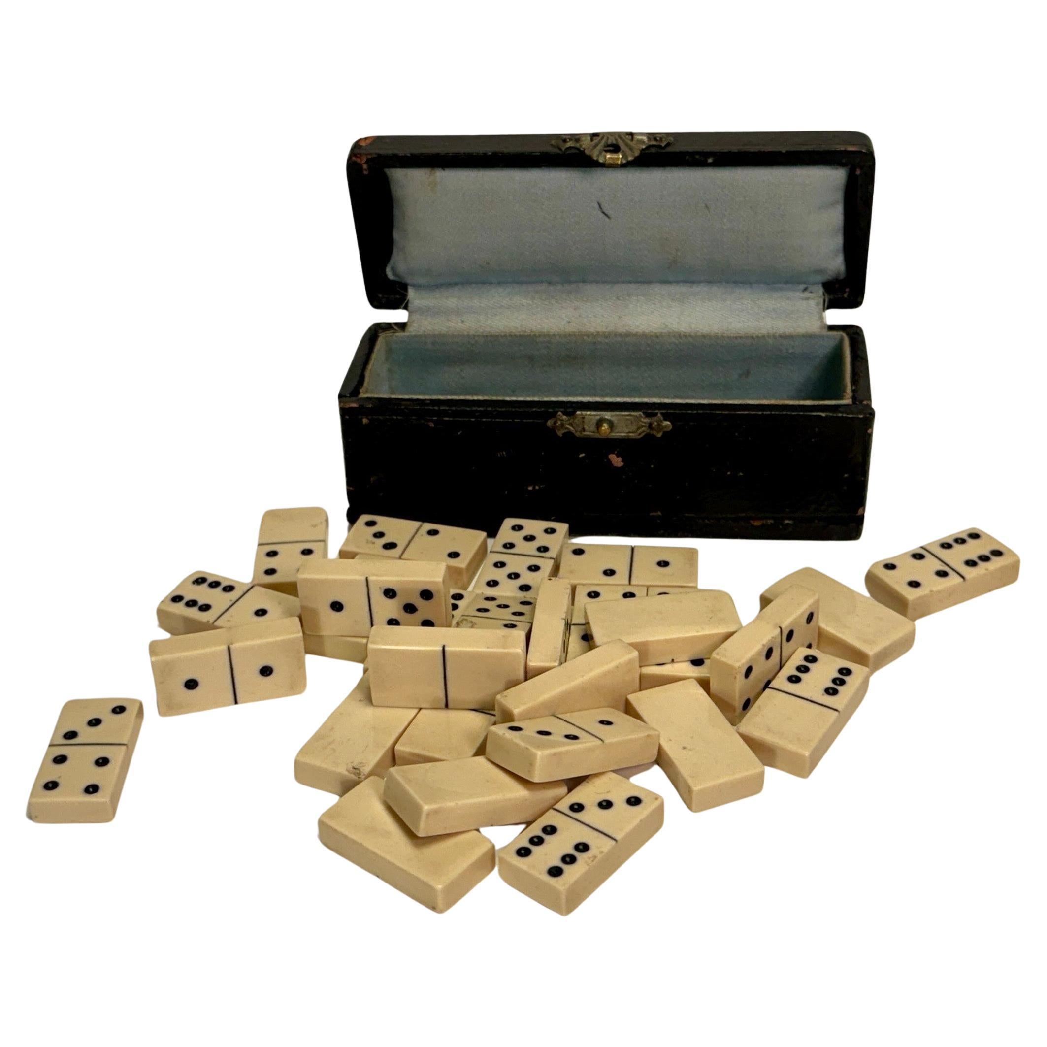 Petite boîte en cuir noir contenant un jeu de société Dominos, 28 pièces en vente