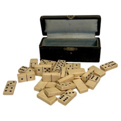Petite boîte en cuir noir contenant un jeu de société Dominos, 28 pièces