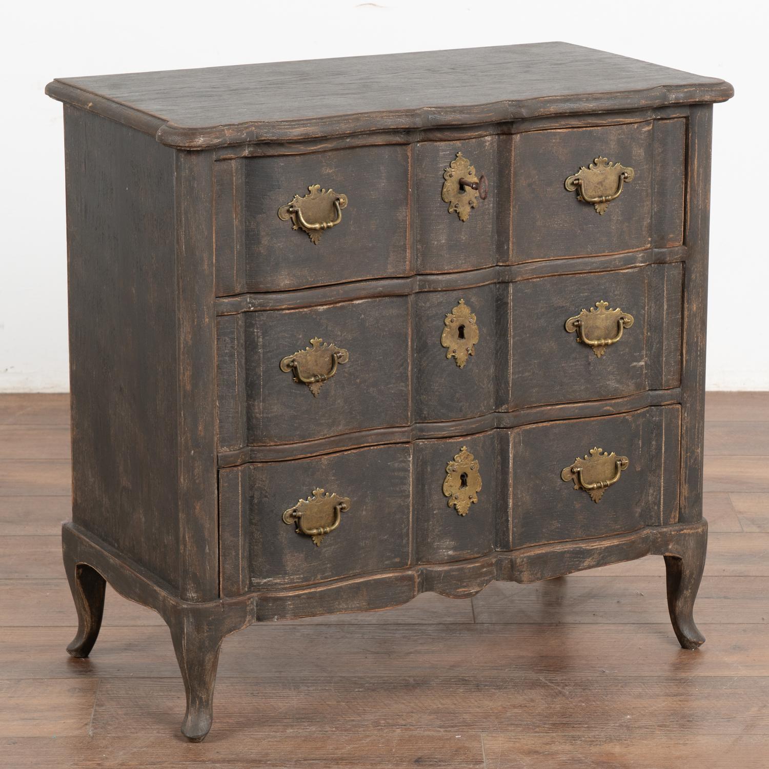 This small chest of three drawers has a touch of dramatic appeal thanks to the (newer/professional) black painted finish that is gently distressed, accenting the Rococo curves and cabriole feet.
The size makes it adaptable to use as a nightstand,
