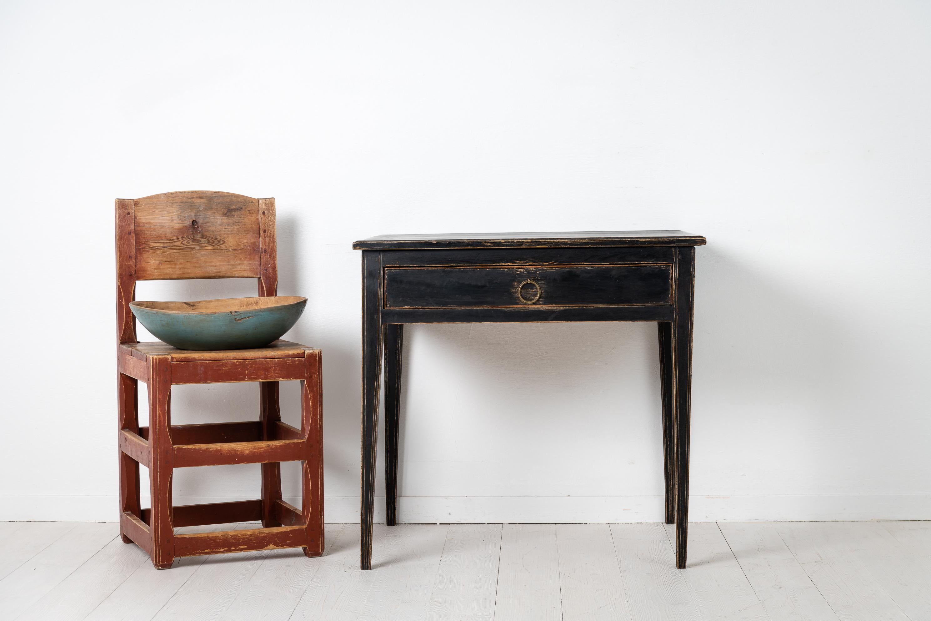 Small black table from Sweden made during the early 1800s. The table is from the Swedish gustavian period which is simliar to the concurrent neoclassical period. The table is slim and elegant with straight tapered legs and a large centred drawer.