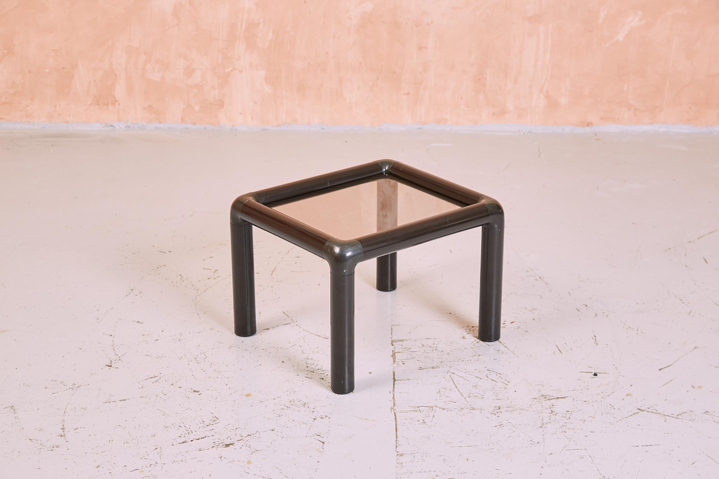 A small 1980s post modern style tubular black plastic side table with smoked glass.