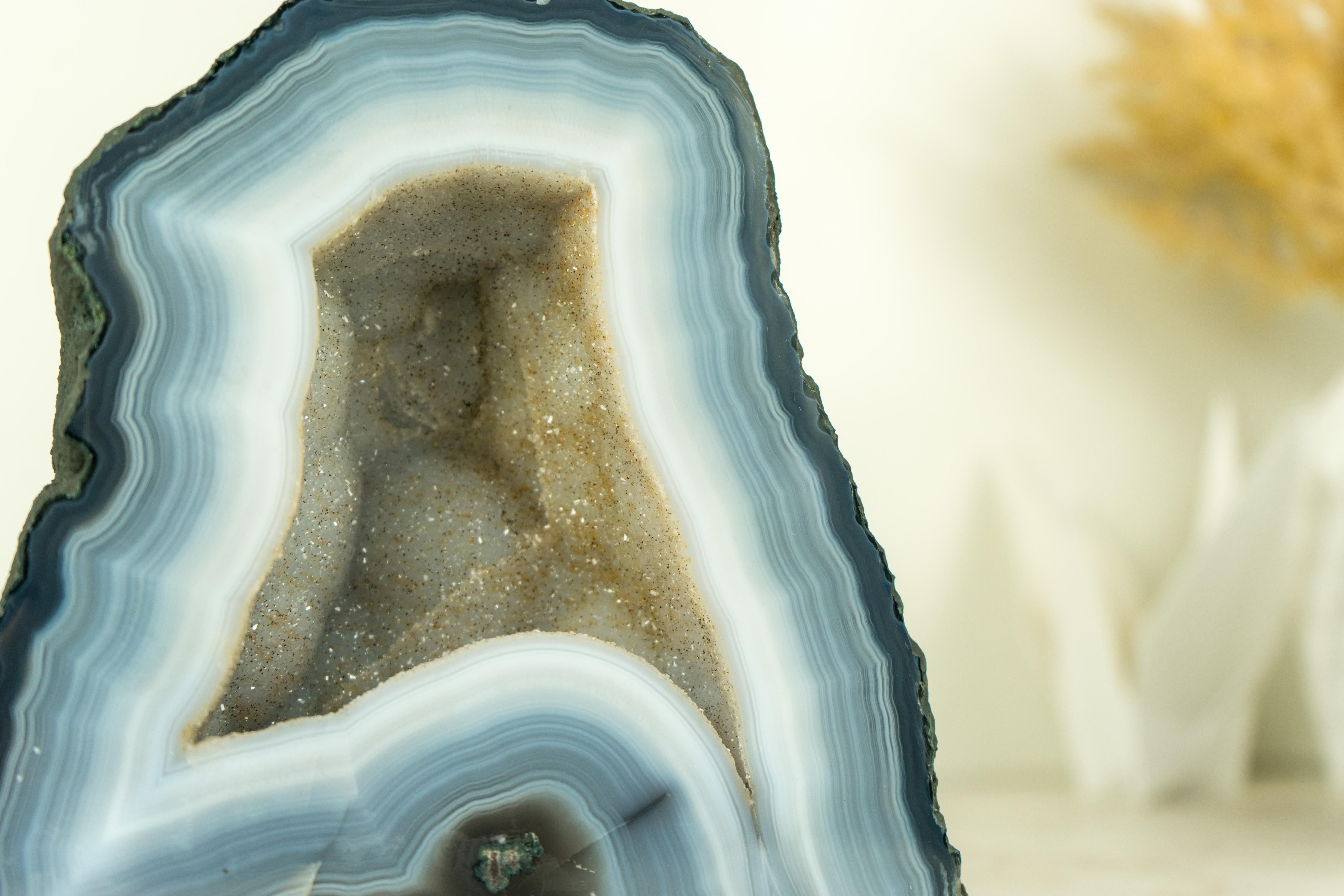 Small yet stunning, this Blue and White Lace Agate Geode brings numerous flawless natural agate laces, along with sparkly white galaxy crystals that form the beautiful aesthetics of the geode. It's undoubtedly a standout specimen for your space and