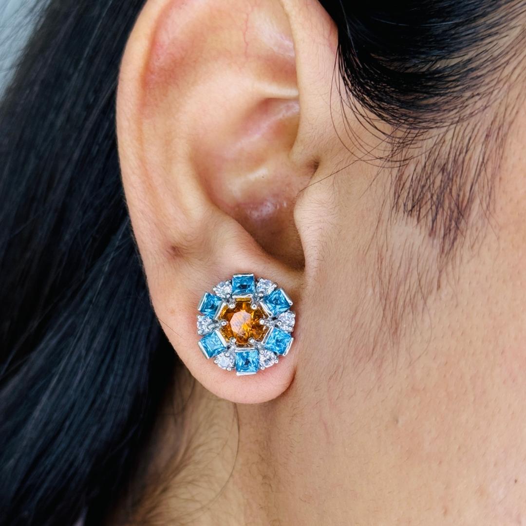 Modernist Multi Gemstone Round Earrings in sterling silver to make a statement with your look. You shall need studs earrings to make a statement with your look. These earrings create a sparkling, luxurious look featuring, mixed cut natural blue
