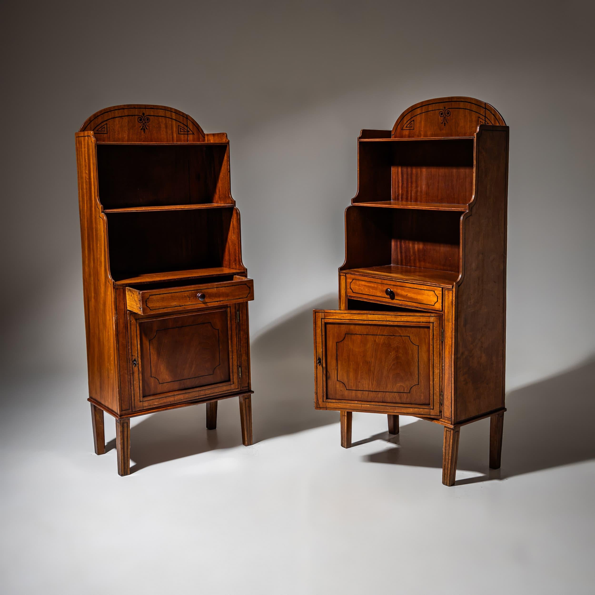 Coppia di librerie o étagères del XIX secolo. Ognuno di essi presenta due ripiani aperti, un cassetto e un armadietto inferiore con serratura. Il piano delicatamente arcuato è decorato con delicati dettagli a intarsio. Questi pezzi, che poggiano su