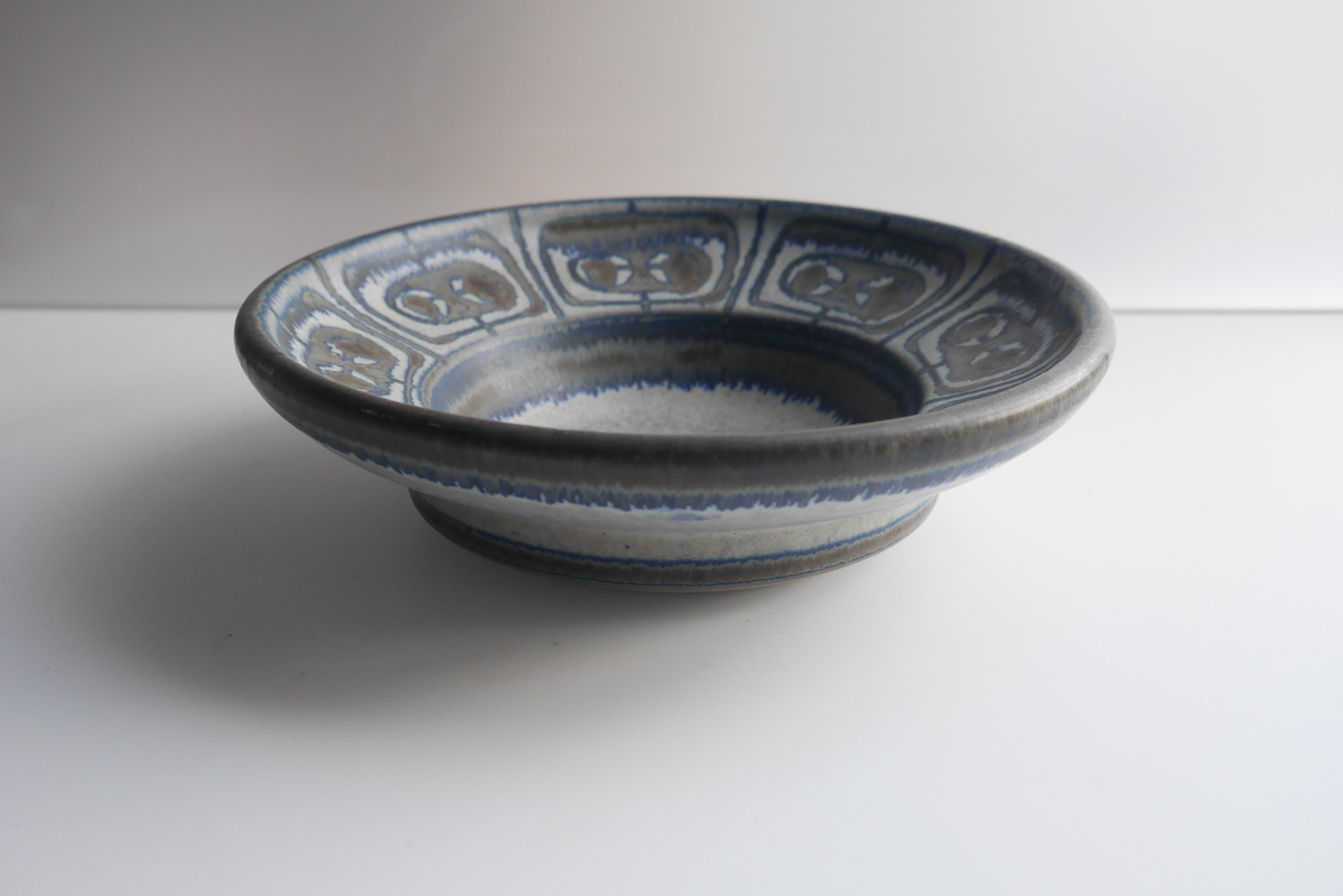 A beautiful shallow bowl or dish by Micheal Andersen for Bornholm ceramics in Denmark. Glazed pattern work around the rim of the piece in subtle matt colors. 

Michael Andersen and Sons Pottery known as (MAS), Bornholm Denmark. 

Michael Andersen &