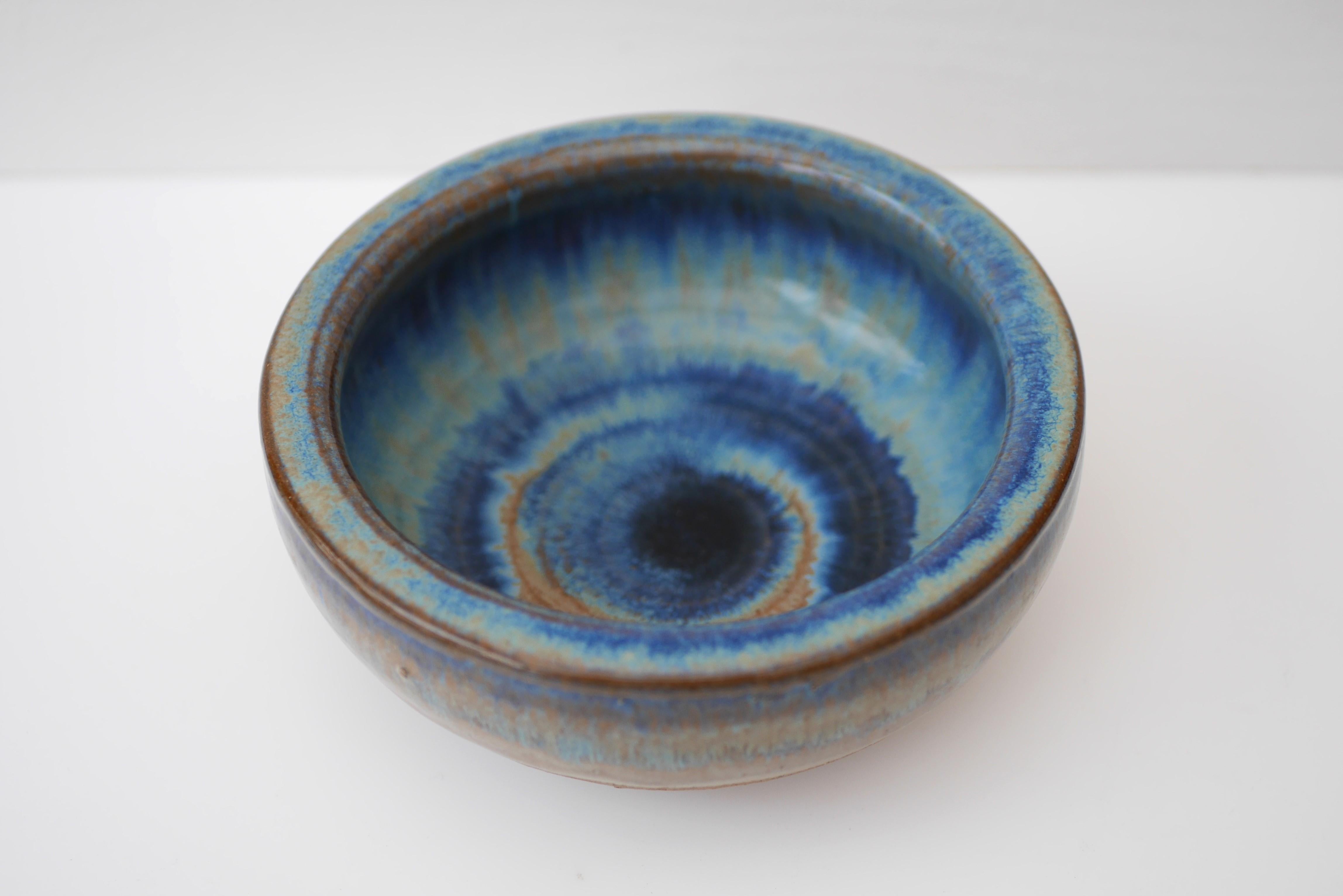 A beautiful stoneware vintage Bornholm pottery bowl from Denmark. Made by the talented Michael Andersen, this bowl is iconic and so typical for this company, especially when it comes to the glazing. The colors are a very nice various shades of blue