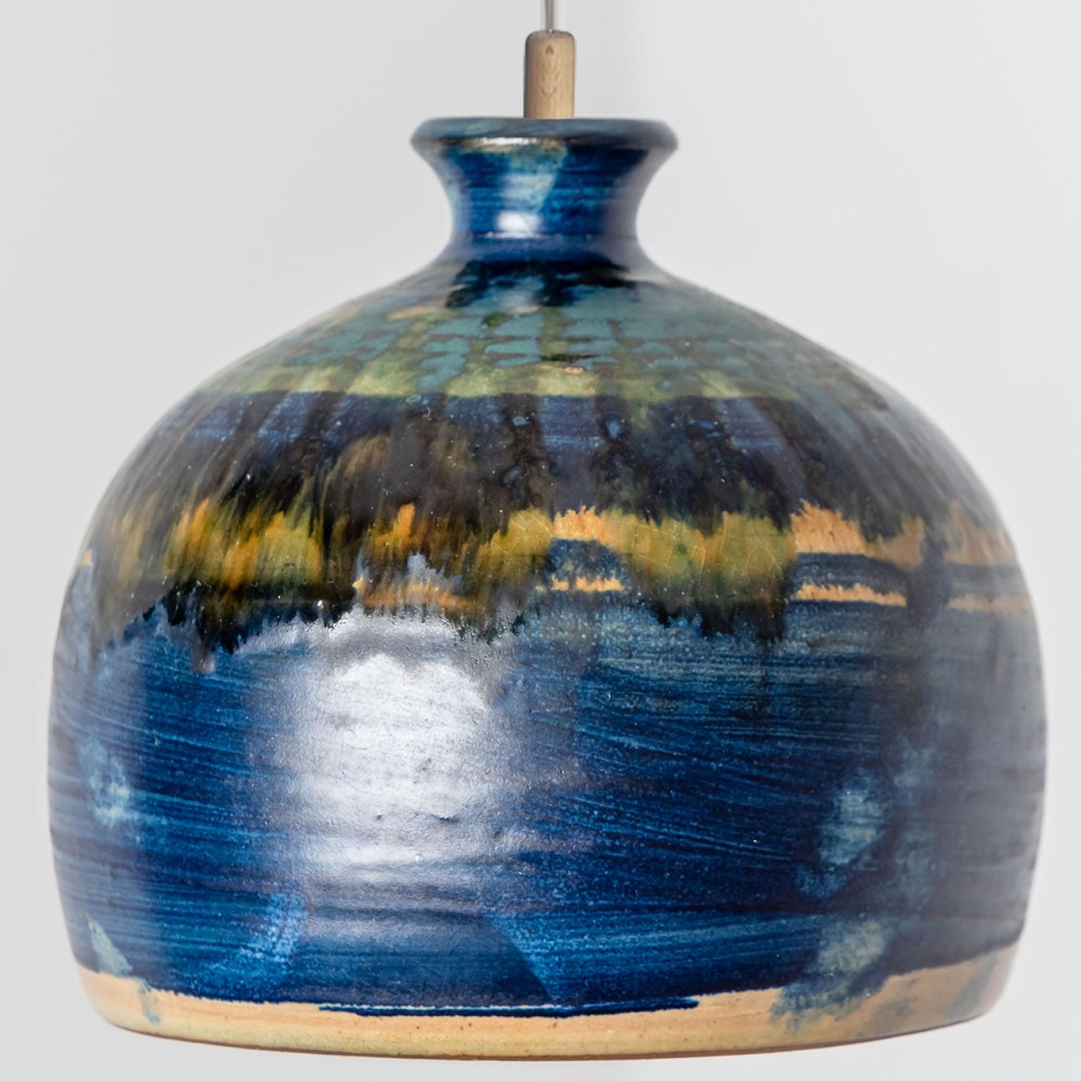 Stunning small round hanging lamp with a bowl-like shape, made with rich aqua-colored cobalt and yellow ceramics, manufactured in the 1970s in Denmark. We also have a multitude of unique colored ceramic light sets and arrangements, all available in