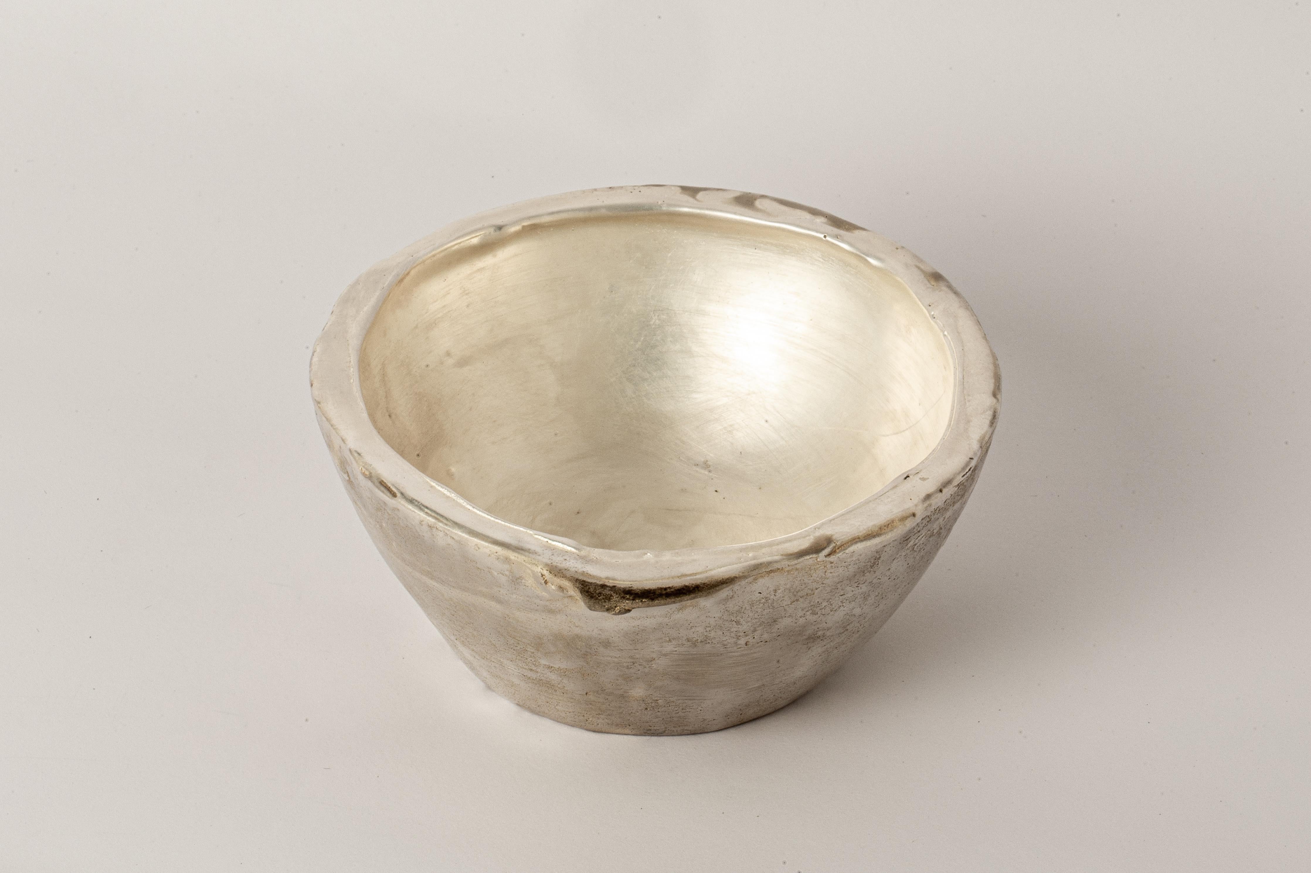 Small bowl in brass electroplated with silver. It is a harmonious fusion of textures and tones that gleams with radiant elegance. Its exterior, adorned with a subtle, tactile roughness, imparts a unique character and charm to piece. Perfect for