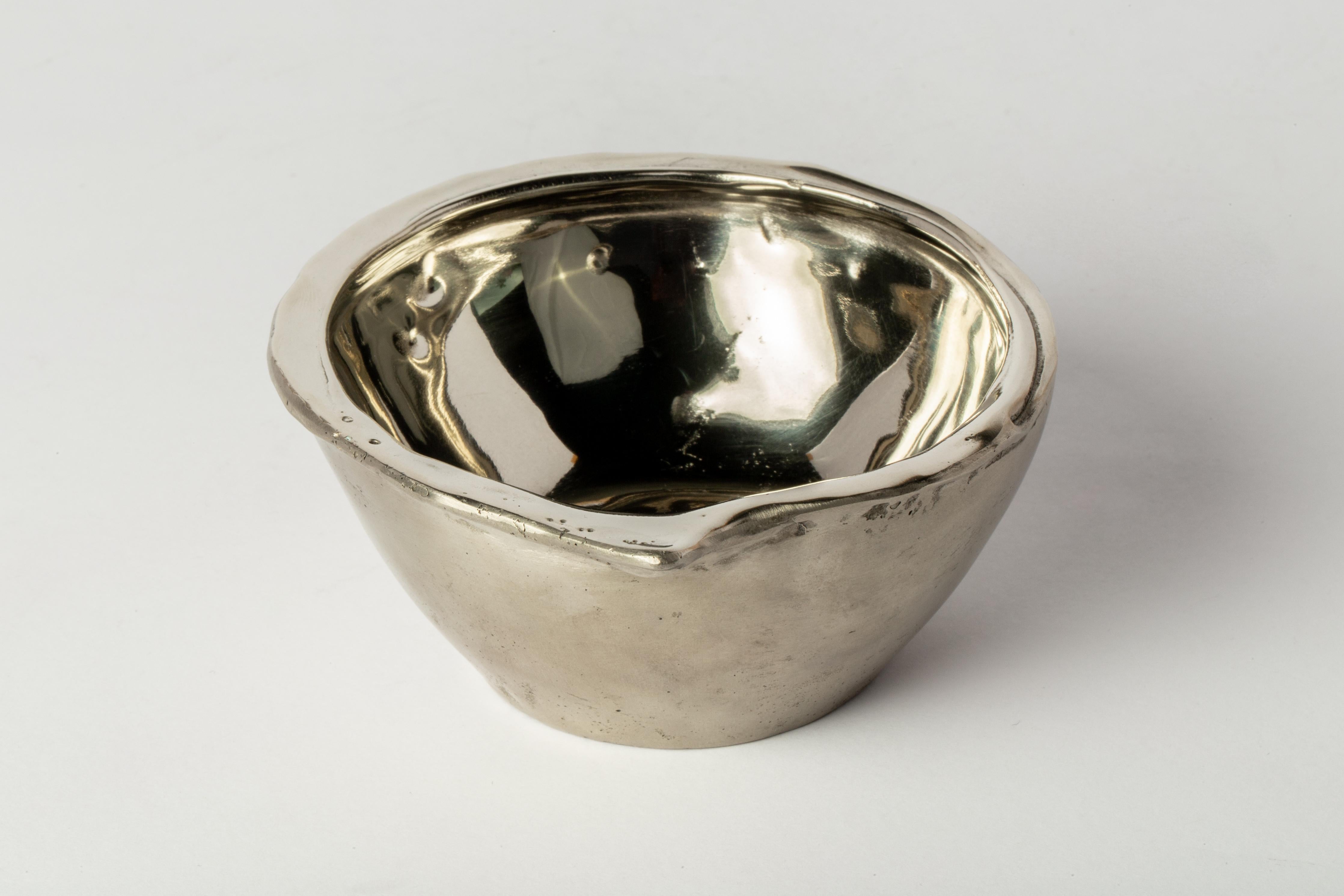 Le petit bol en bronze blanc, dont l'intérieur est poli jusqu'à atteindre un éclat brillant, est un mélange captivant d'élégance et d'artisanat. Sa surface intérieure épurée et réfléchissante dégage un charme intemporel et sophistiqué, ce qui en